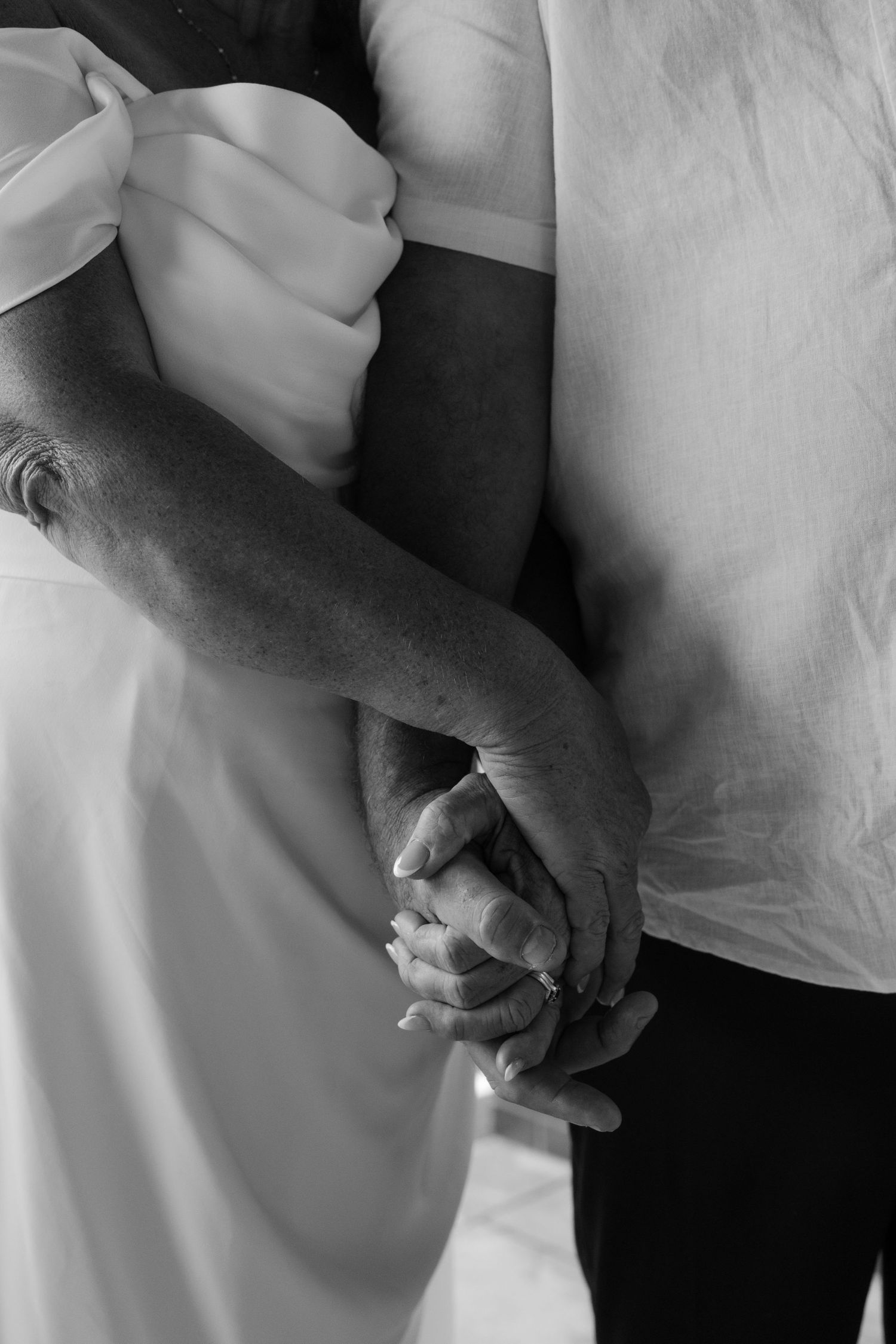 Bride and groom holding hands during a Brisbane wedding ceremony, close-up.