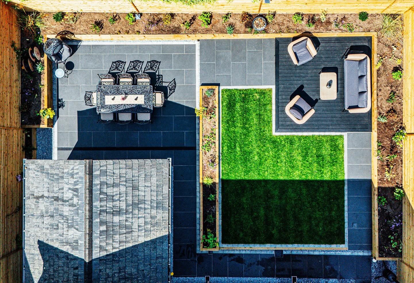 Aerial view of a landscaped garden with slate paving, artificial grass, and outdoor furniture.