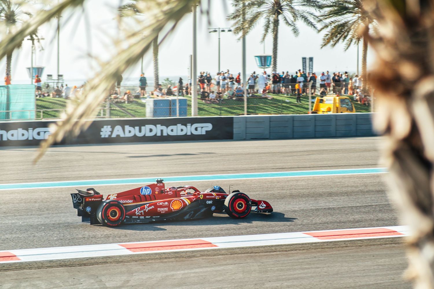 Ferrari and Red Bull Formula 1 cars racing side by side at Abu Dhabi GP circuit.