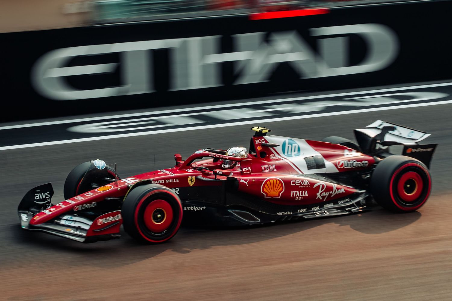 Ferrari Formula 1 car in iconic red livery racing at Abu Dhabi Grand Prix Yas Marina Circuit.