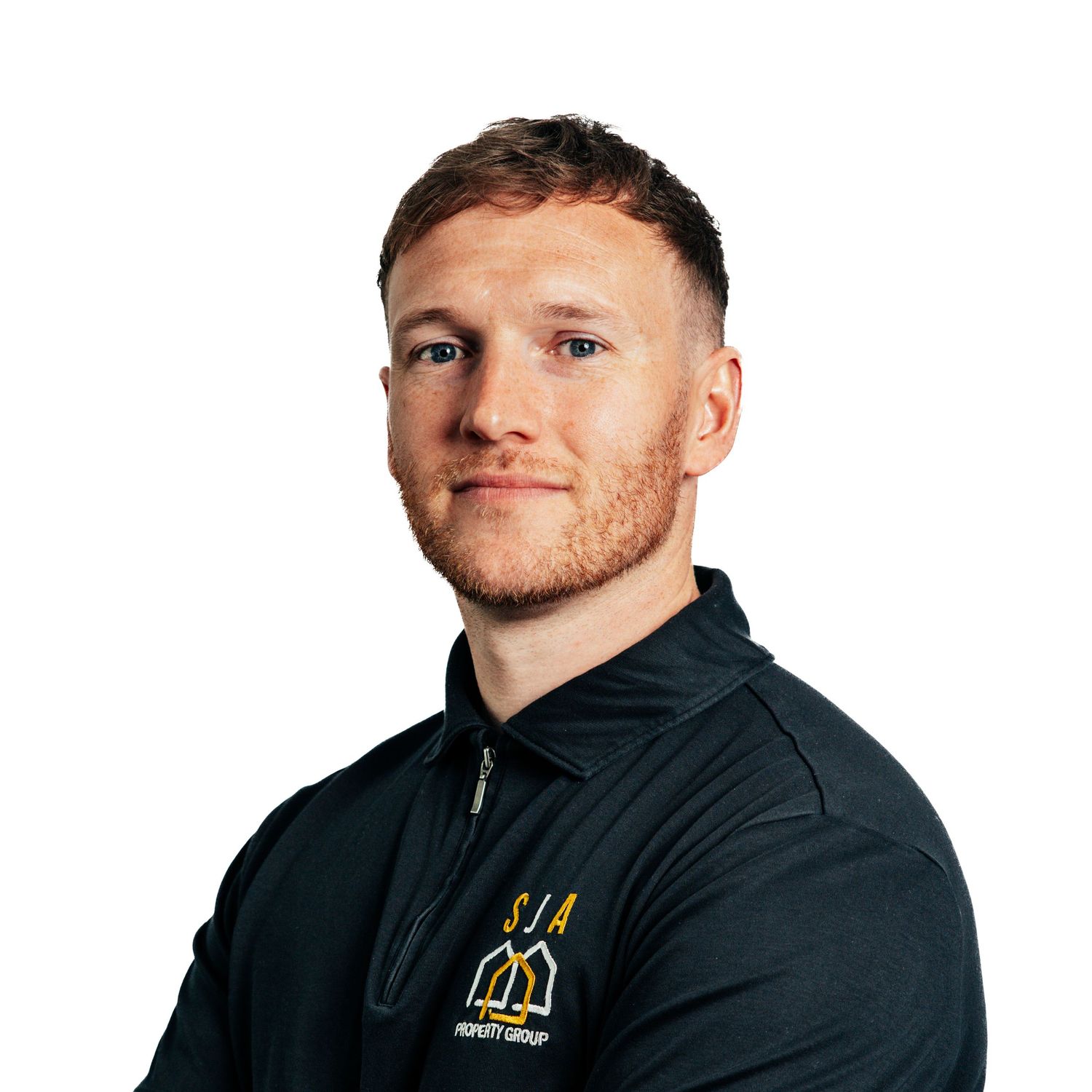 Young man in black SJA Property Group polo shirt smiling against white background.