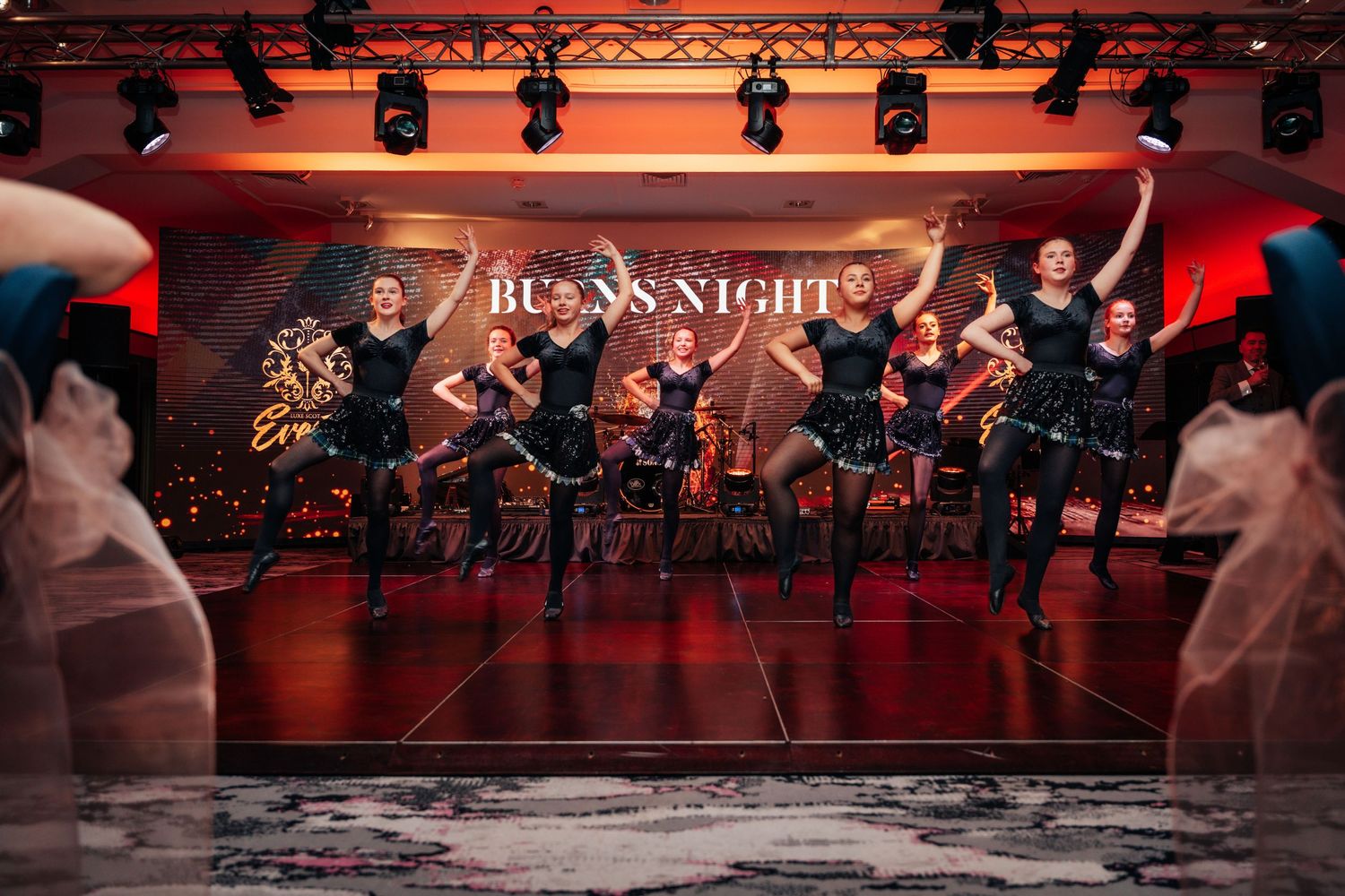 Scottish dancers performing on stage at a spectacular Burns Night celebration event.
