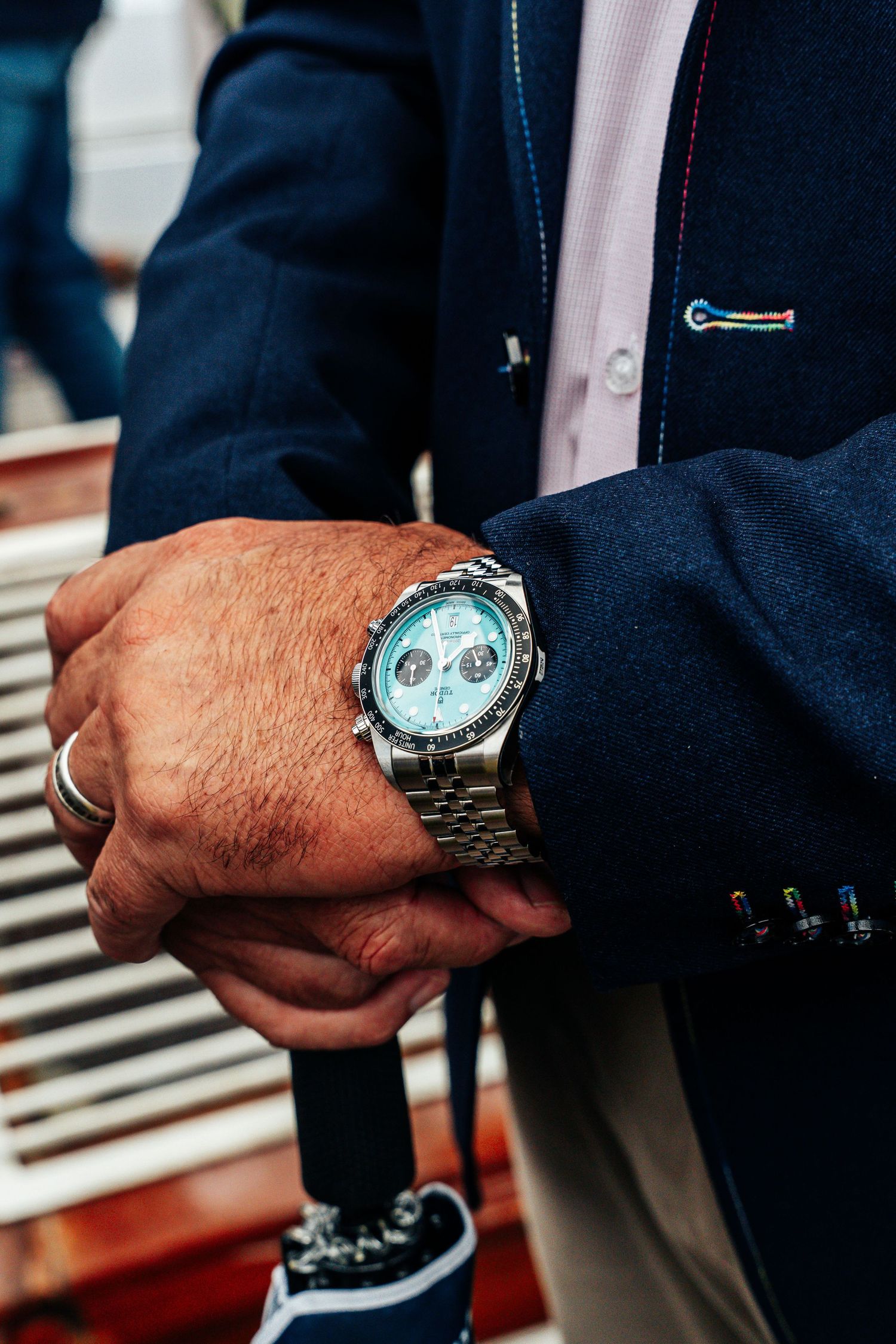 Close-up of a man's wrist wearing a silver chronograph watch with a light blue dial.