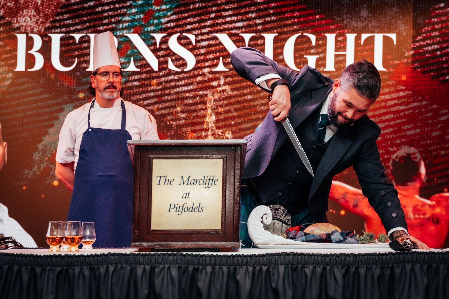 Chef and host performing ceremonial haggis address at The Marcliffe Burns Night event.