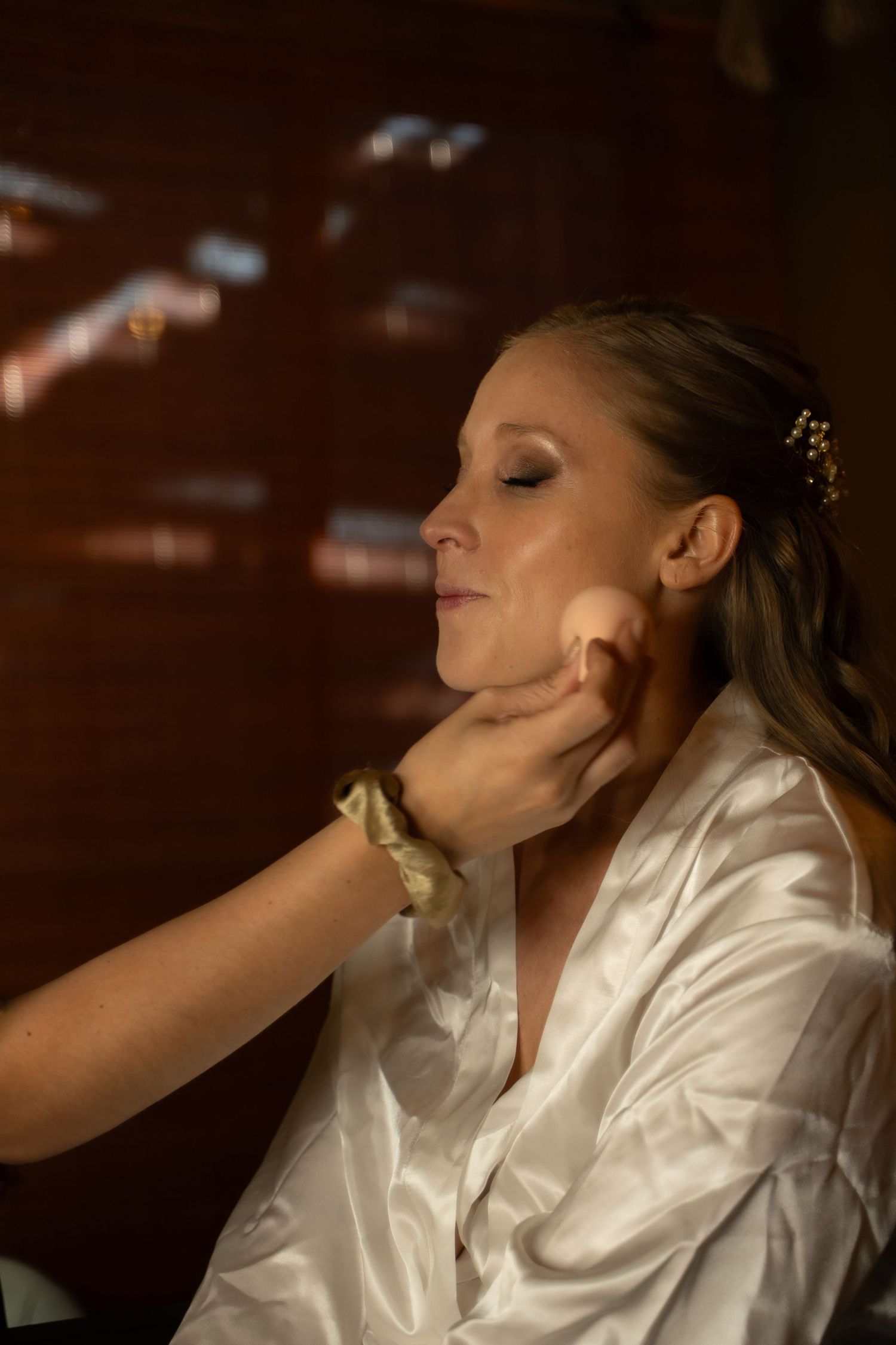 Person in white satin robe tilting head back in dramatic lighting.