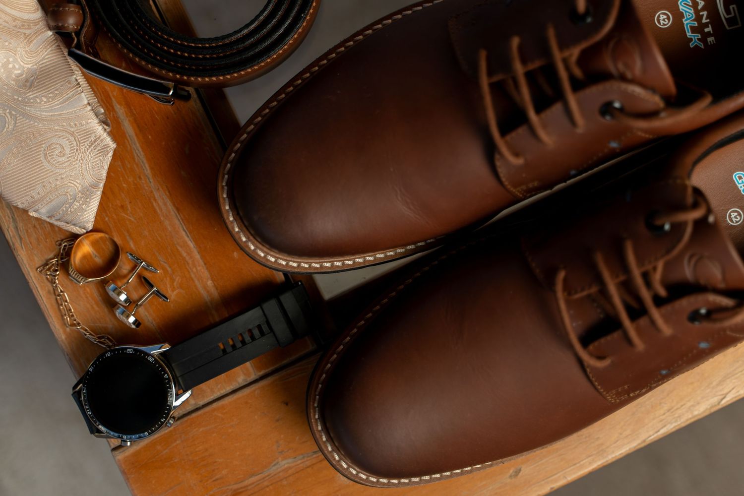 Close-up view of brown leather dress shoes being polished and shined with traditional shoe care tools.