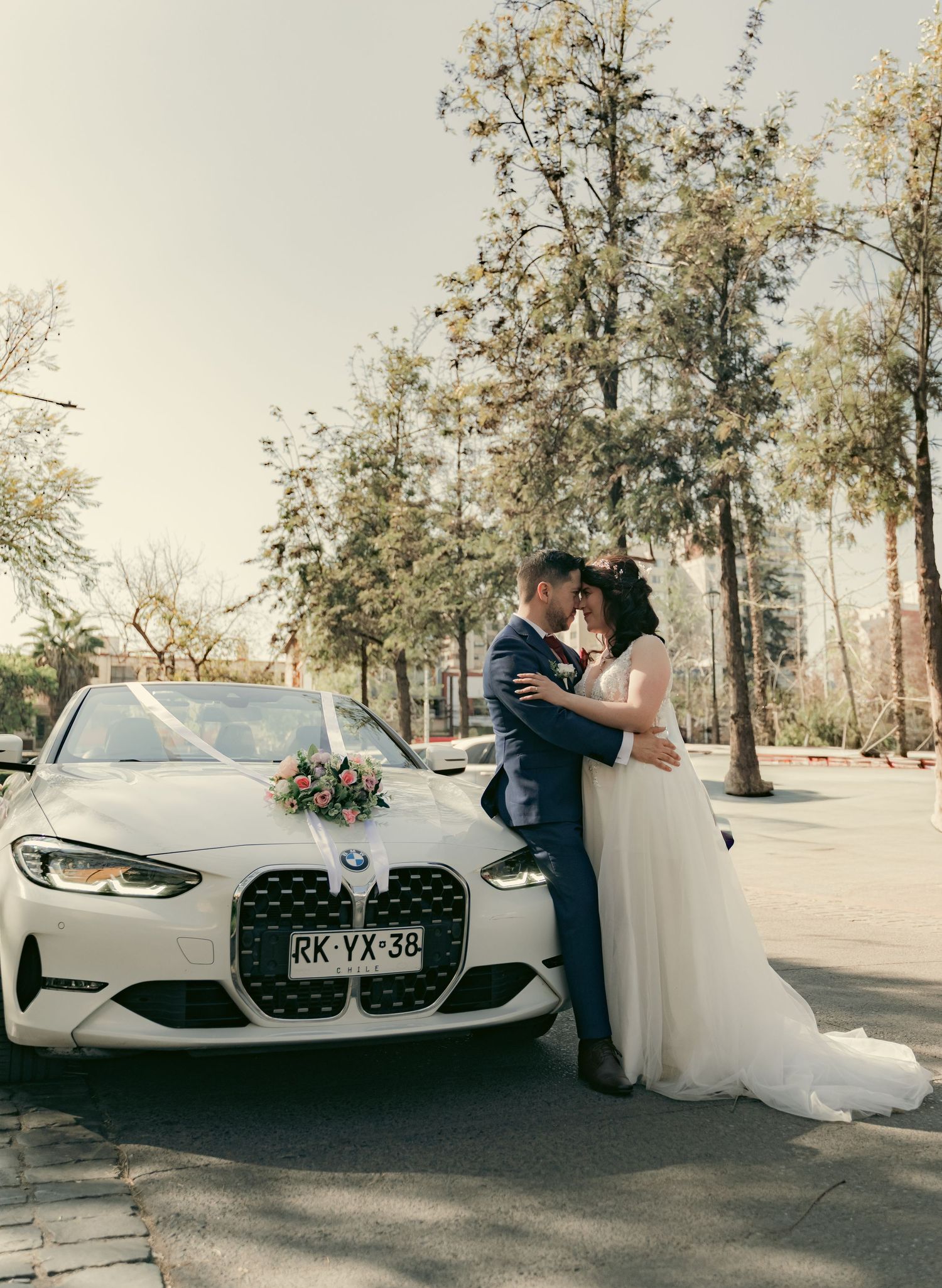 Wedding photo sequence with couple posing beside a white luxury car.