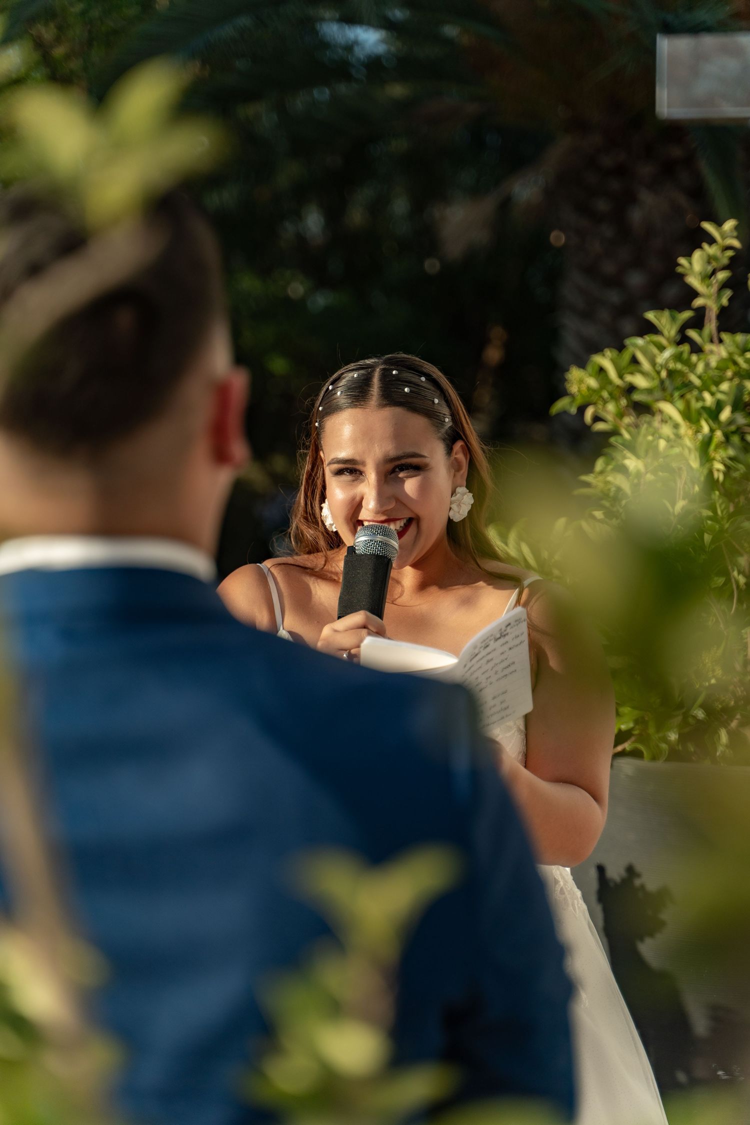 A joyful wedding moment captured between a couple in an outdoor garden setting.