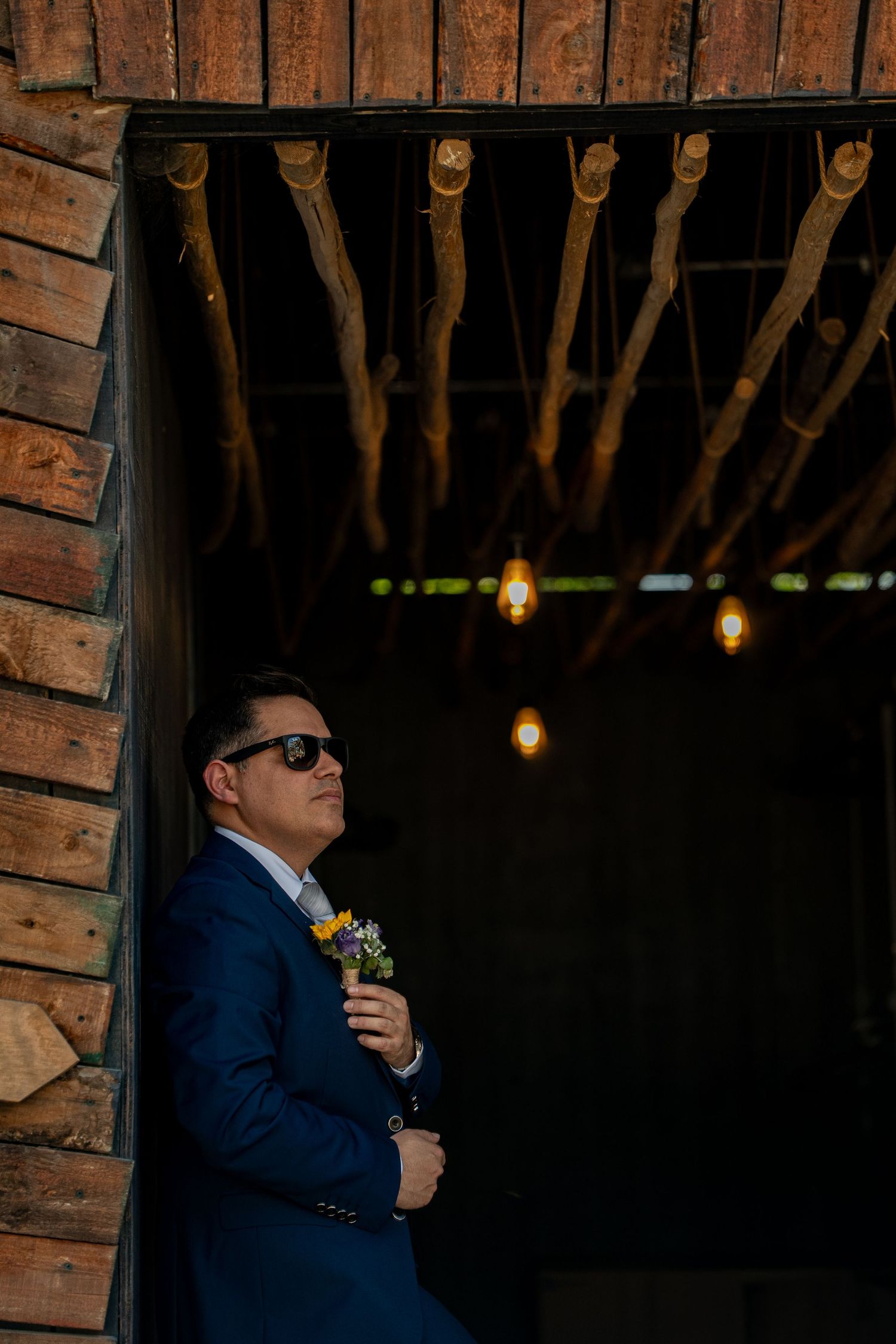 Dimly lit rustic venue with hanging lights and exposed wooden beams creating moody ambiance.
