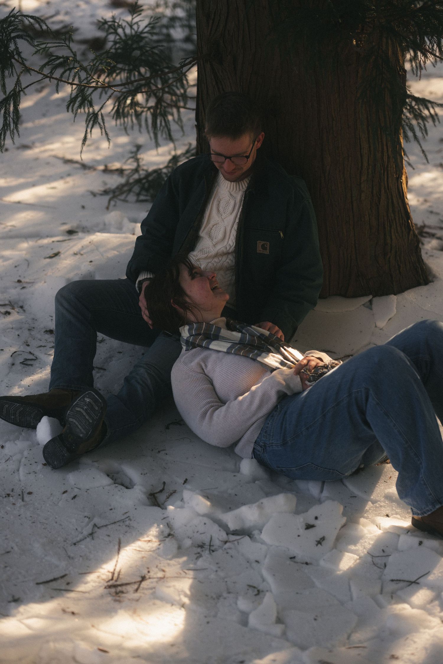 A coupled leaned up against the tree. The girl is looking at her boyfriend. The picture is a photograph in Winchester, VA.