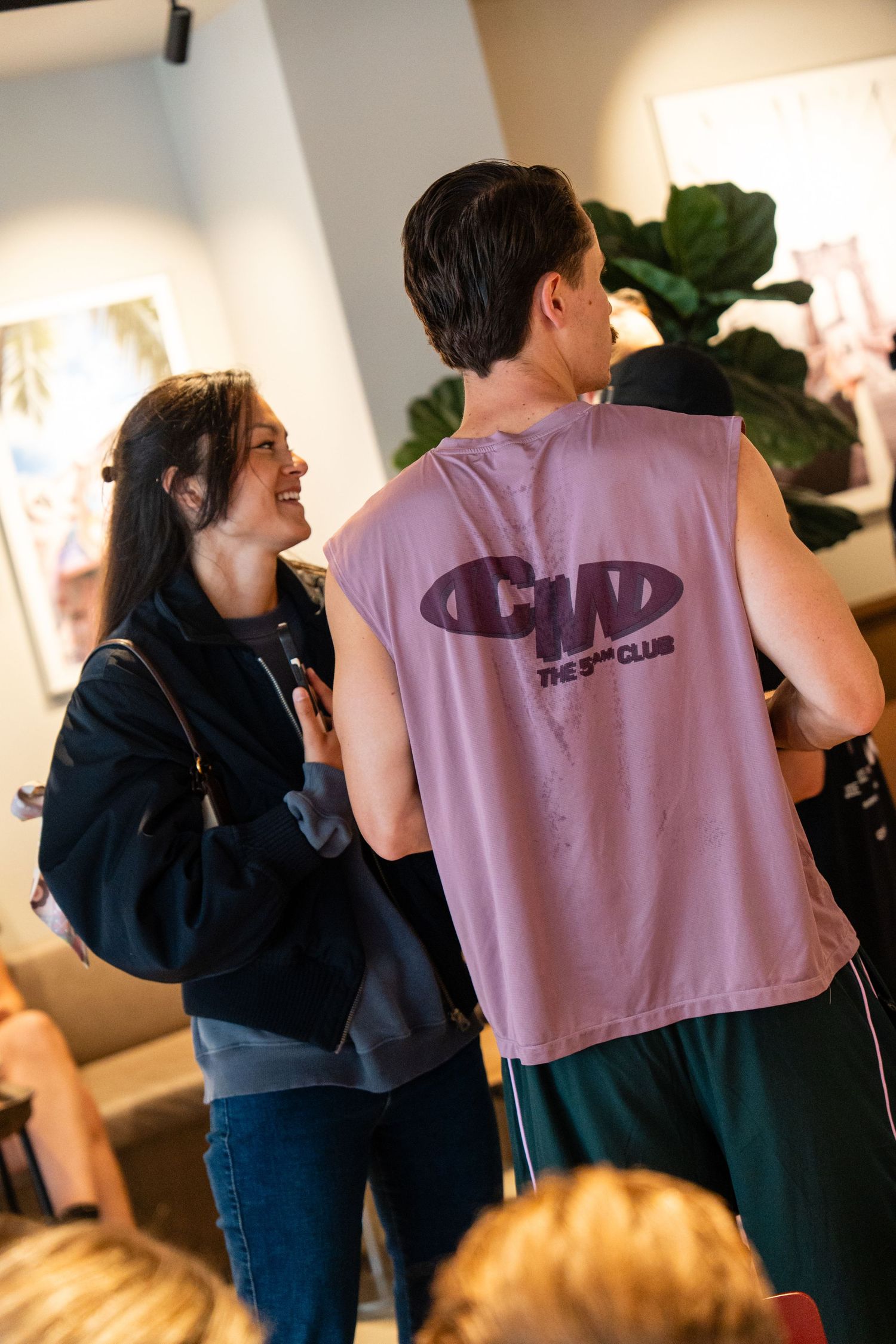 Young couple smiling and chatting at an indoor social gathering event.