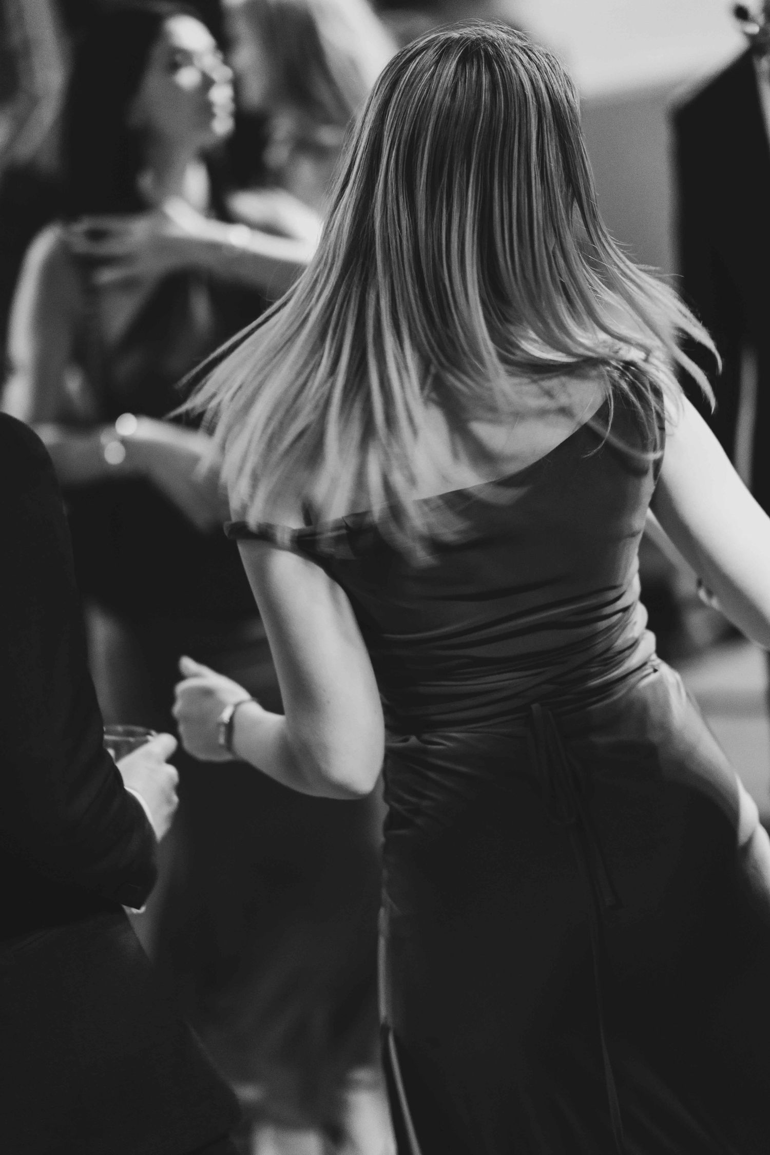 Black and white photo of a woman in an elegant dress dancing at a formal event.