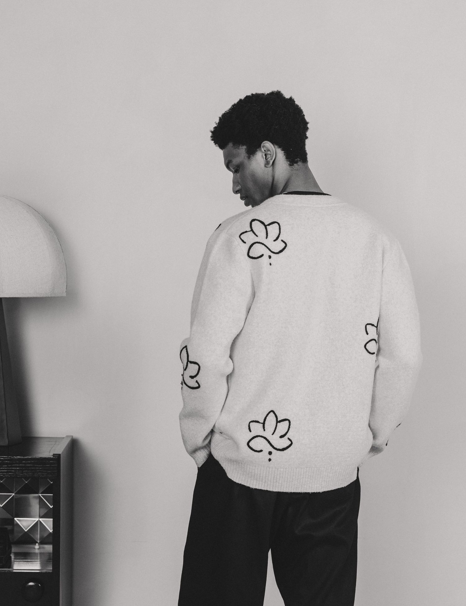 A series of black and white photos showing a person's back with delicate floral line drawings on their skin.