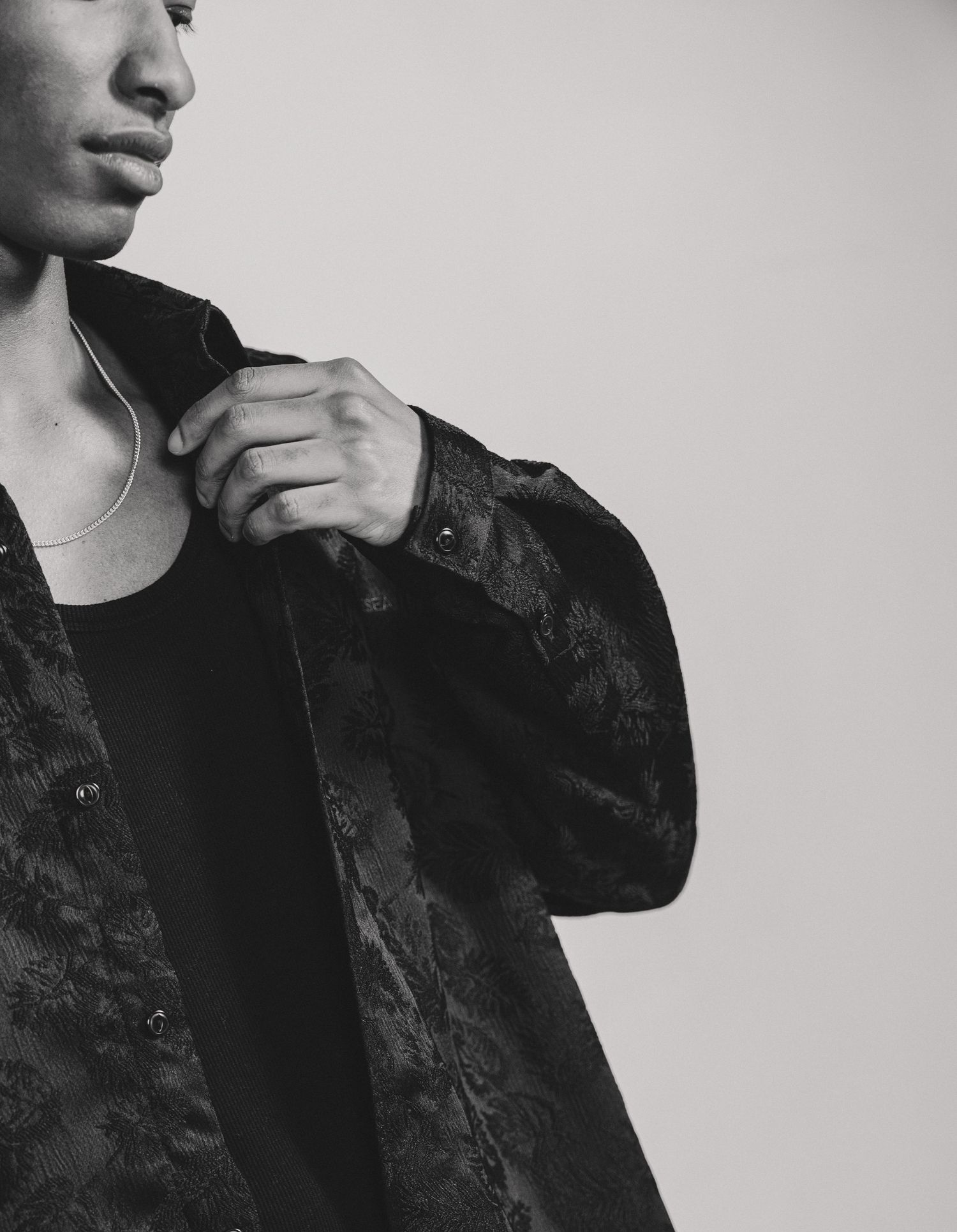 A black and white portrait series showing someone wearing a dark jacket against a light background.