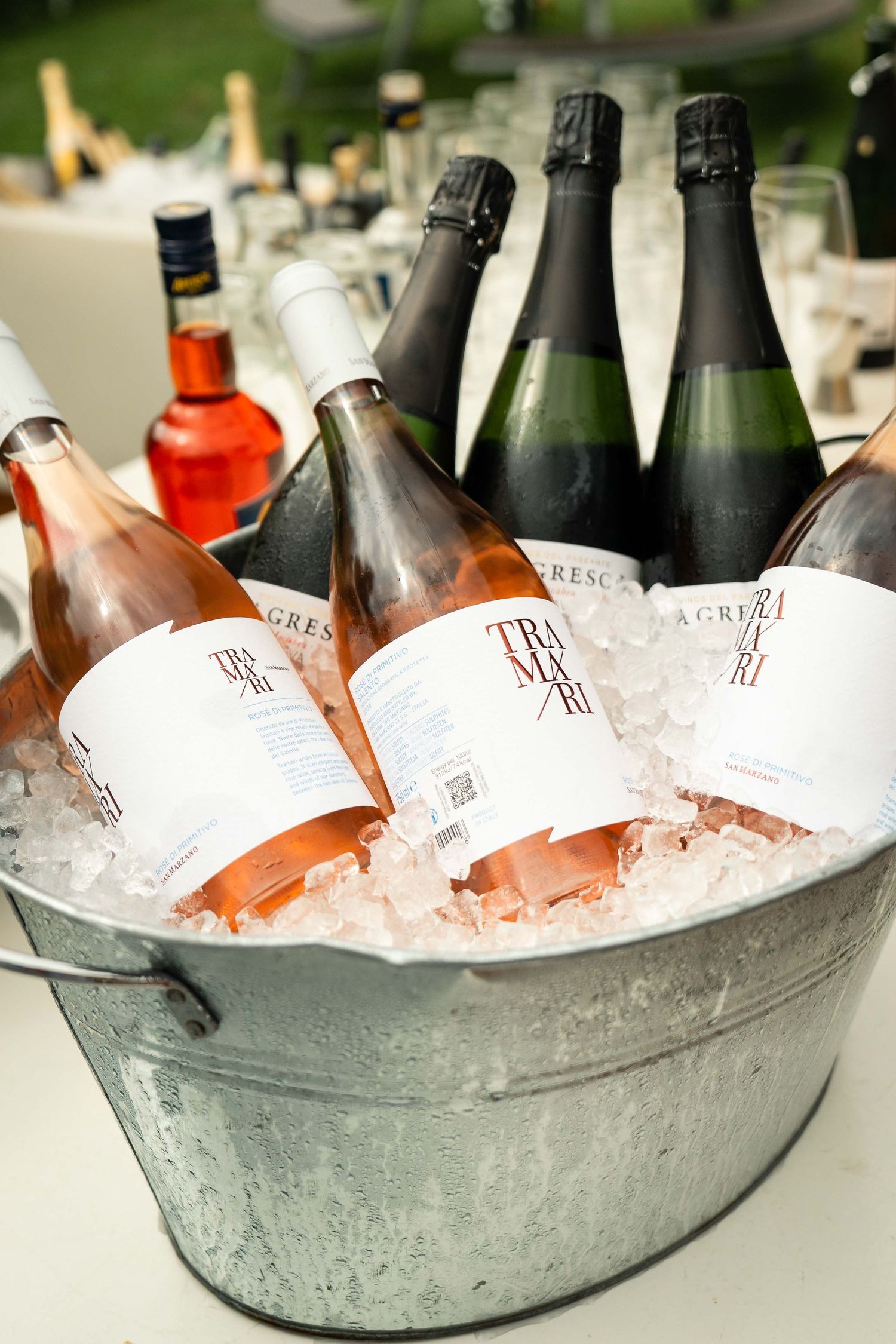 Chilled bottles of Tra Ri sparkling rosé wine and La Gresca prosecco on ice in a silver metal bucket.