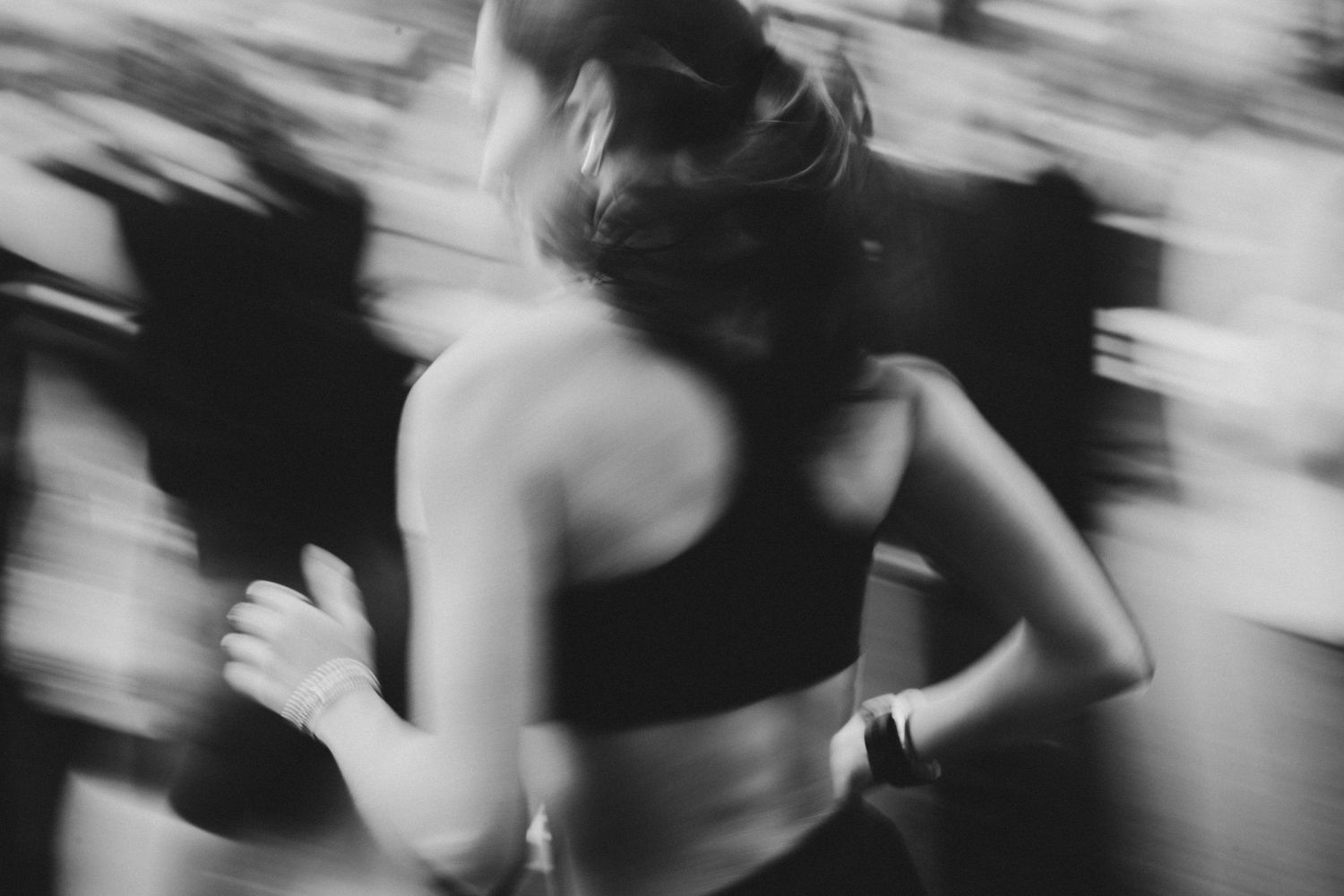Black and white motion blur capture of runner in athletic wear.