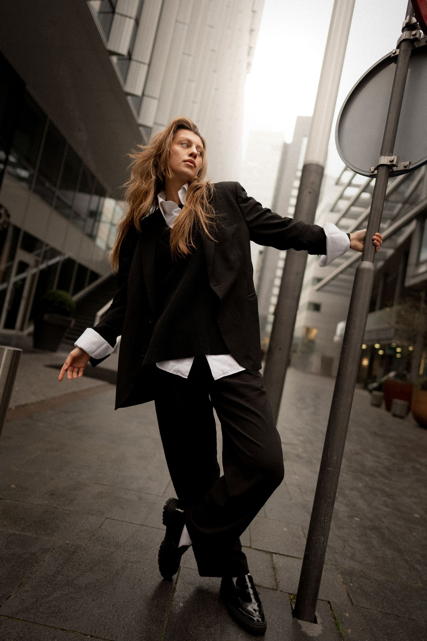 Urban fashion shoot with dramatic angles in modern city setting.