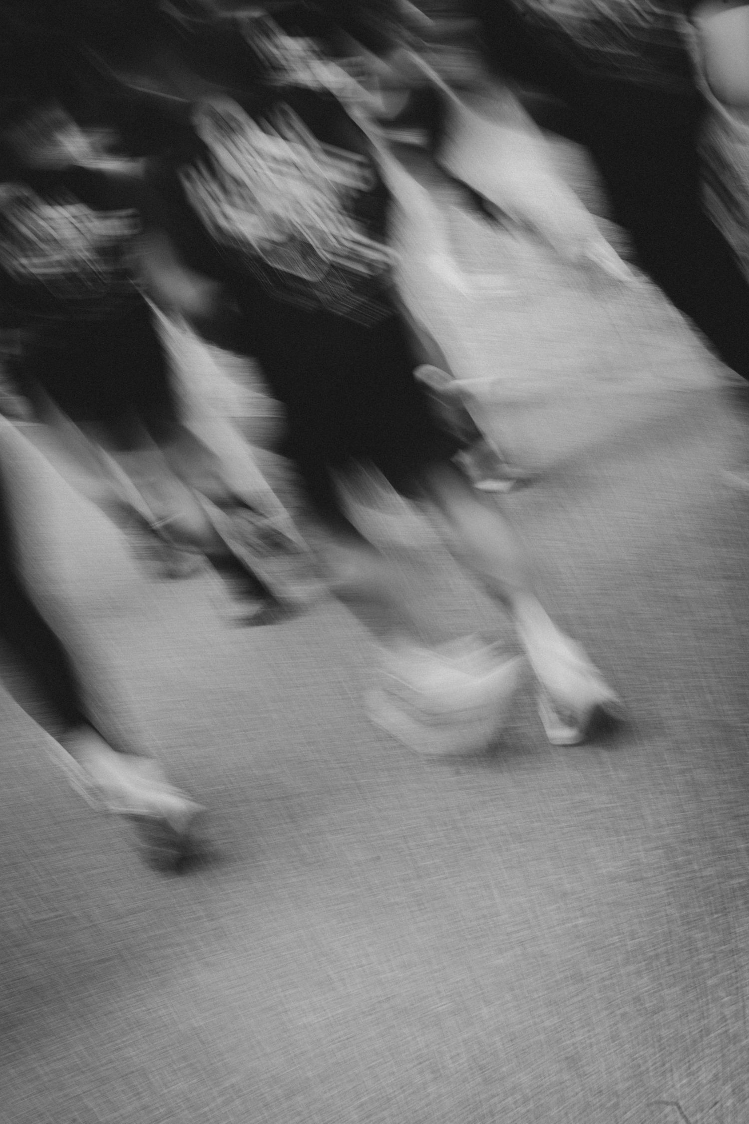 Blurred black and white motion photo of people walking on a street.