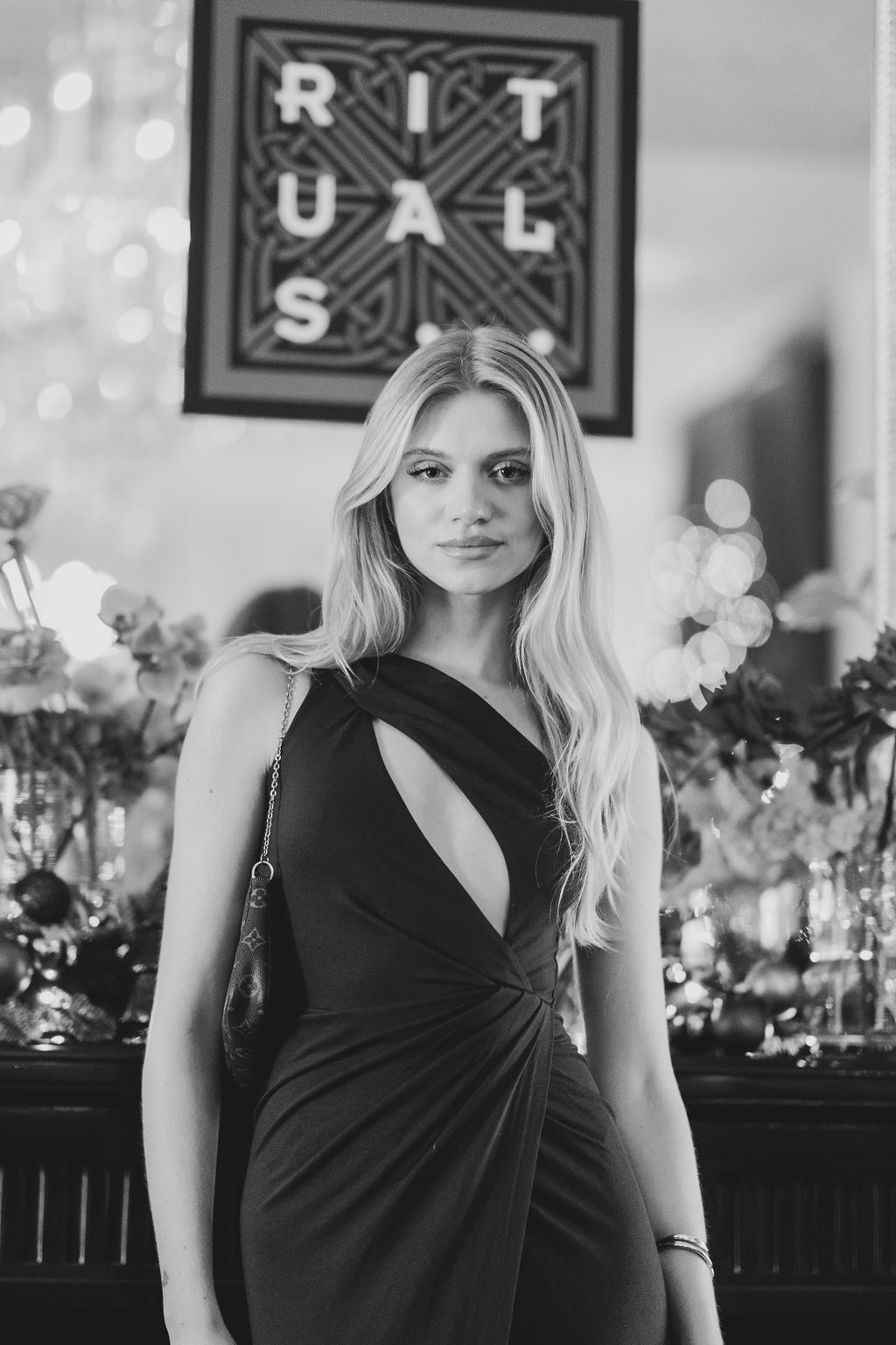 Black and white photo of a blonde woman in an elegant black dress at a Rituals event.