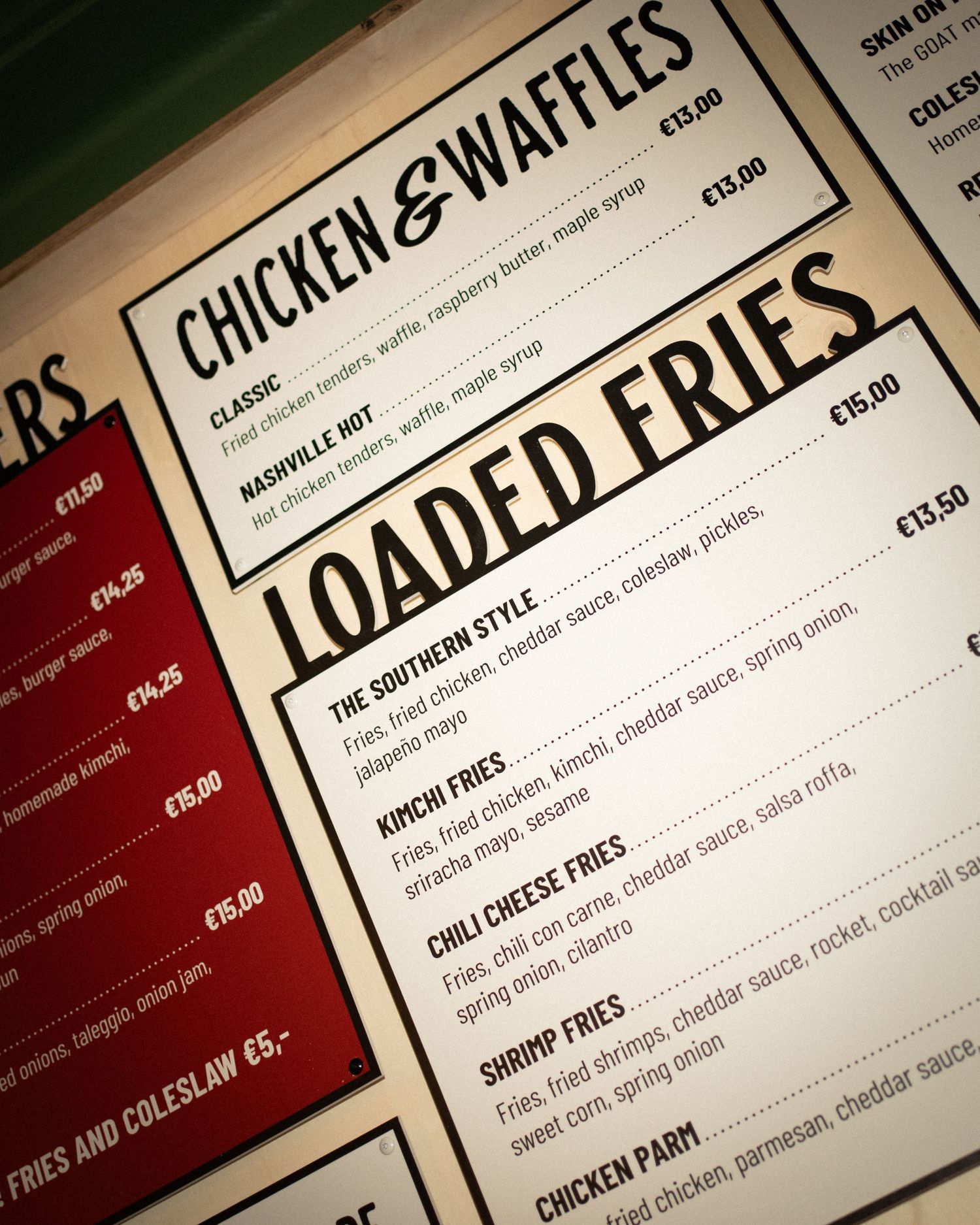 A restaurant menu board featuring Chicken & Waffles and Loaded Fries sections with prices in euros.