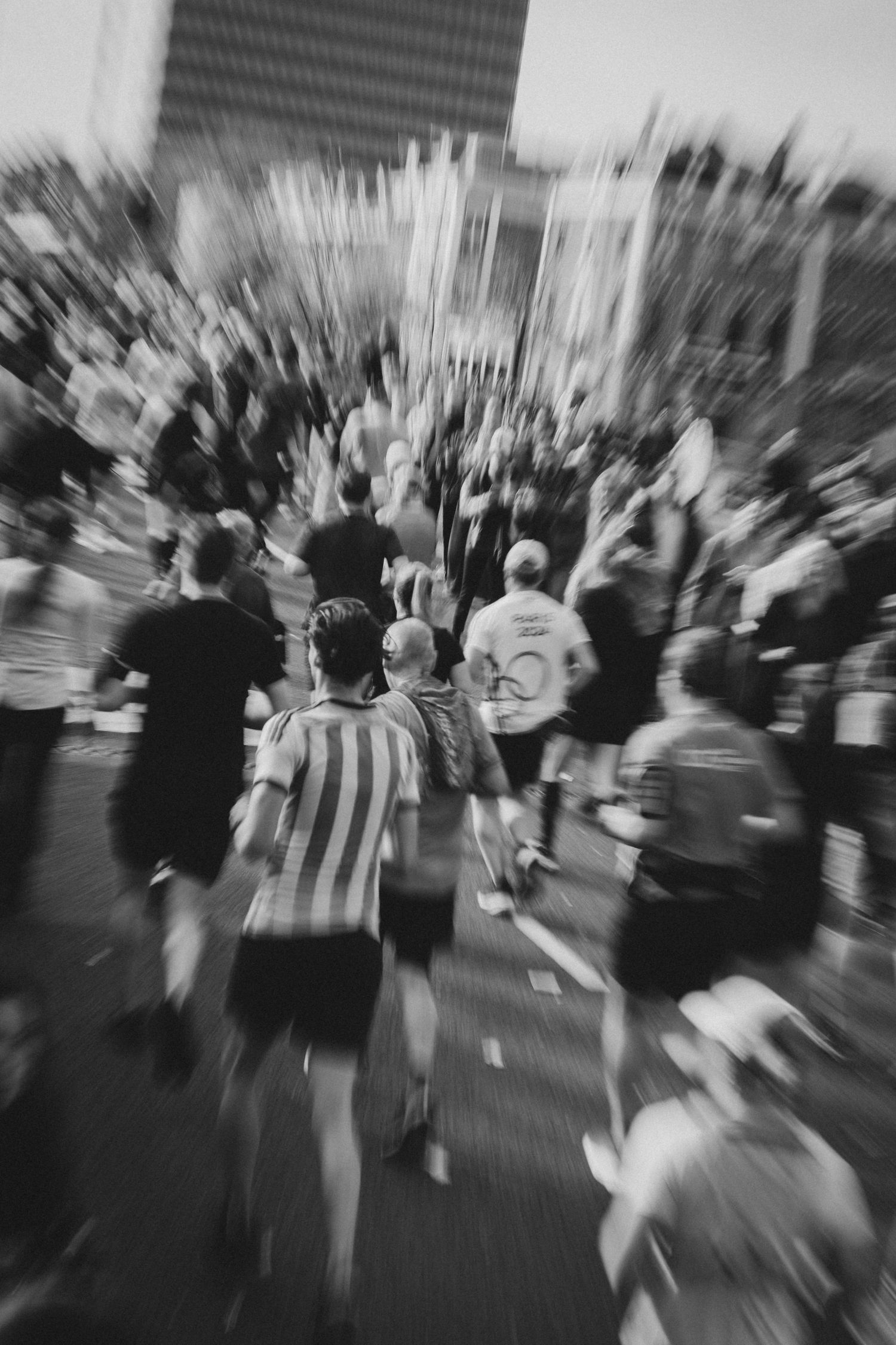 Motion-blurred crowd of marathon runners creates dynamic racing atmosphere.
