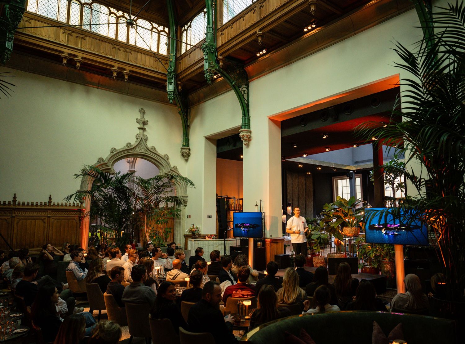 Wide view of a conference hall with high ceilings and decorative architecture.