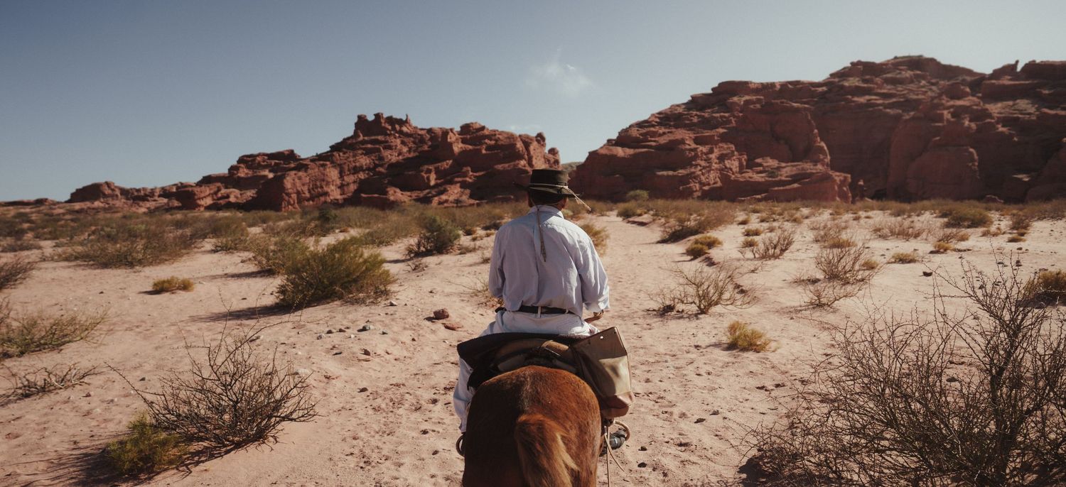 Scenic red rock formations and desert landscape under blue sky in the American Southwest.
