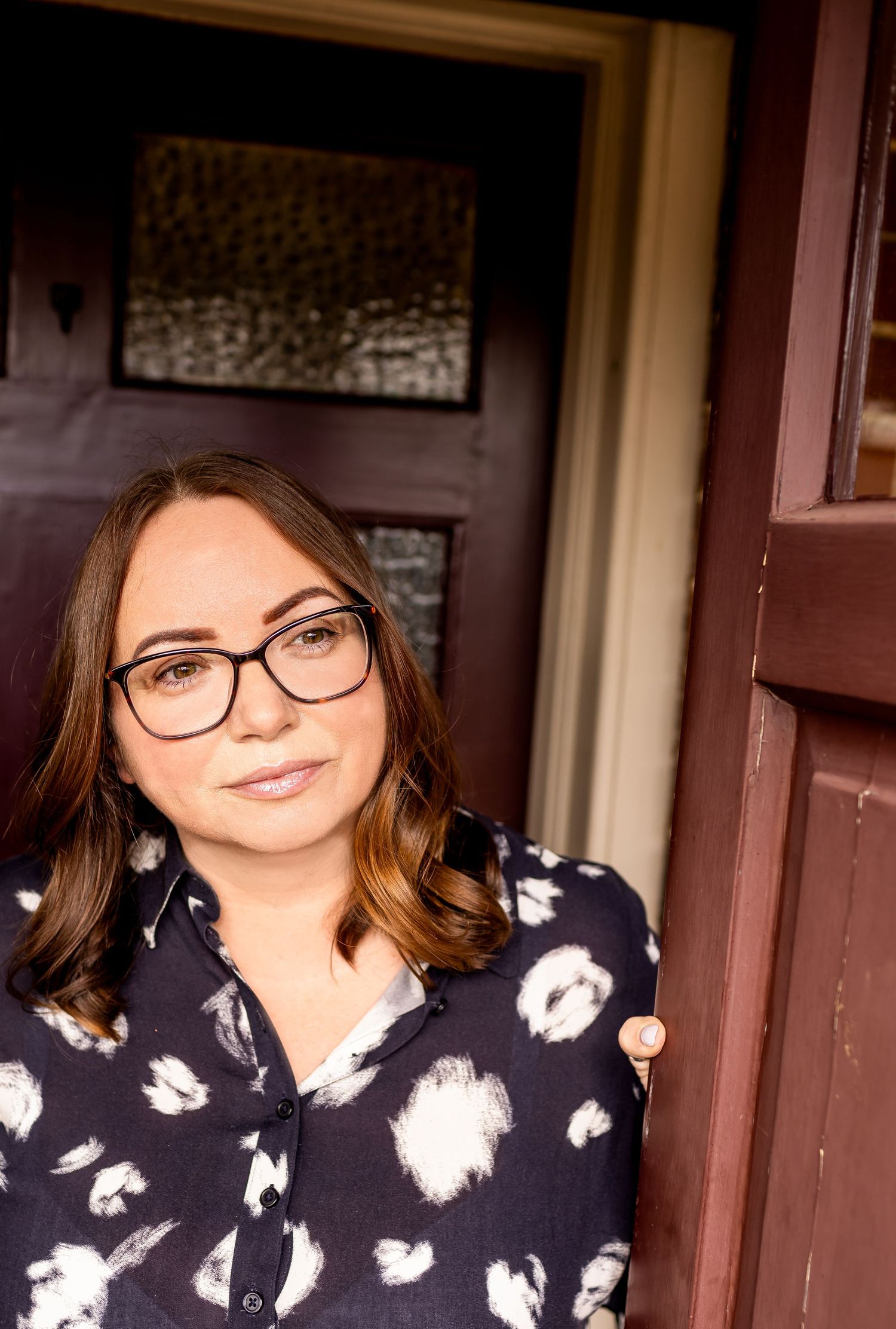Casual portrait series taken in doorway with dark wood trim.