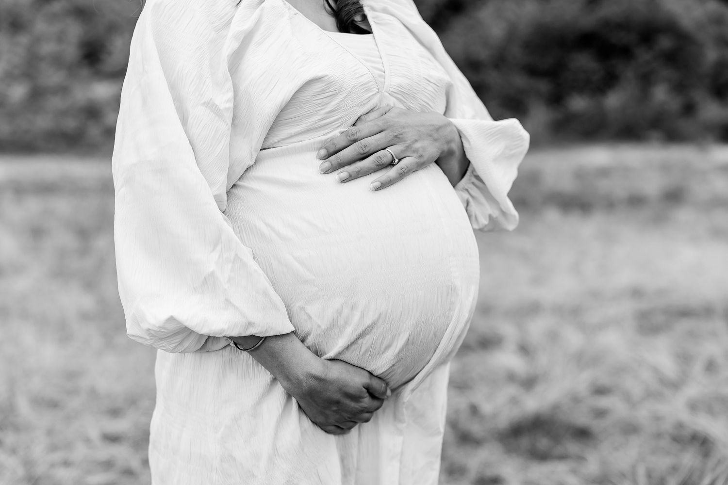 Series of outdoor black and white maternity photos showing gentle belly poses in natural light.