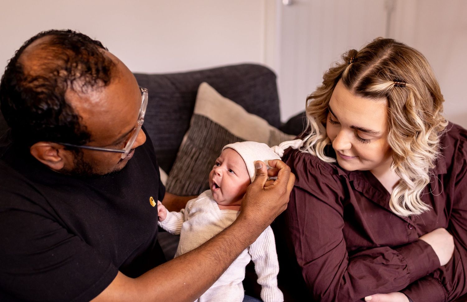 Tender family moment with newborn baby being held by parents.