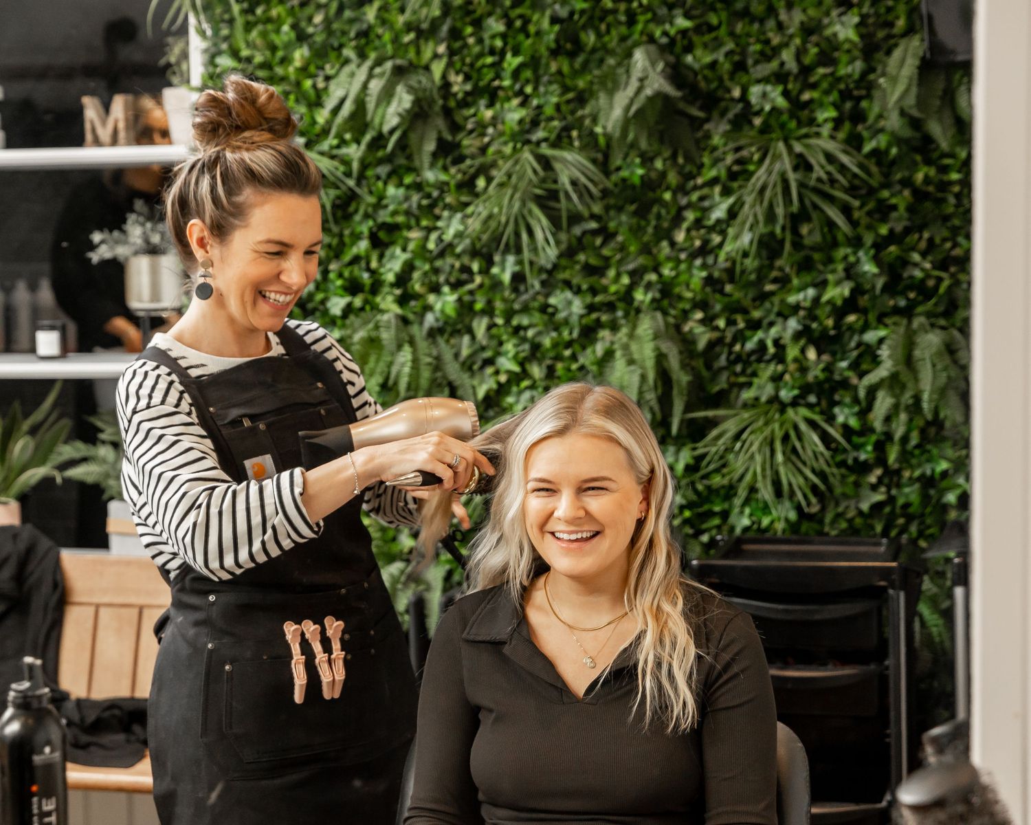 Wedding preparation scene with styling and accessories against green foliage backdrop.