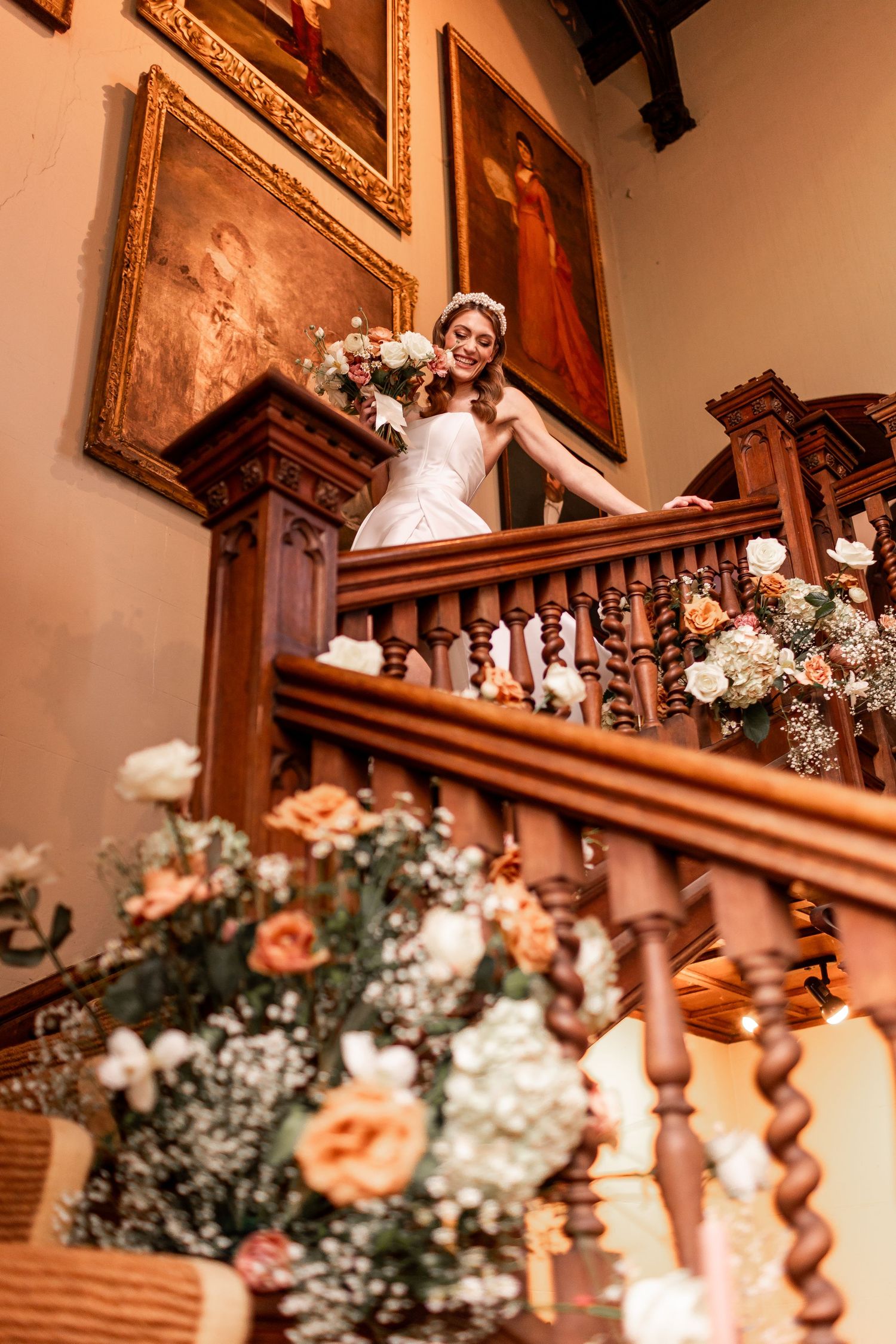 Elegant floral arrangements with peach roses and white blooms decorate wooden church interior.