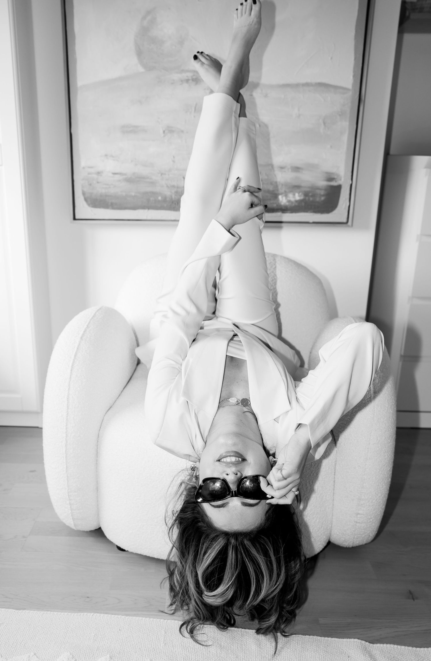 Black and white artistic photo series showing a person in white clothing lying on a wooden floor.