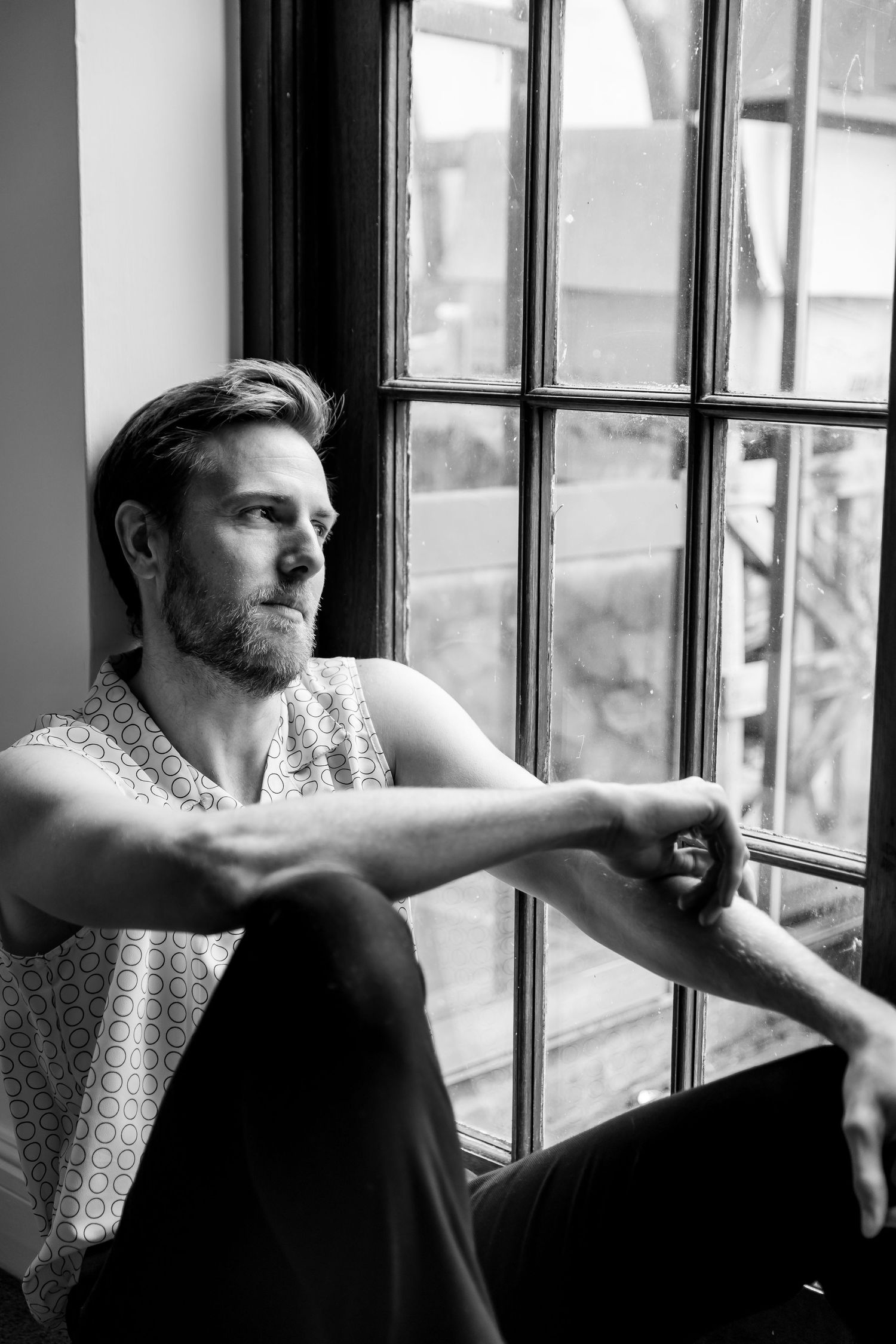 Black and white portrait series of someone gazing thoughtfully out a window.