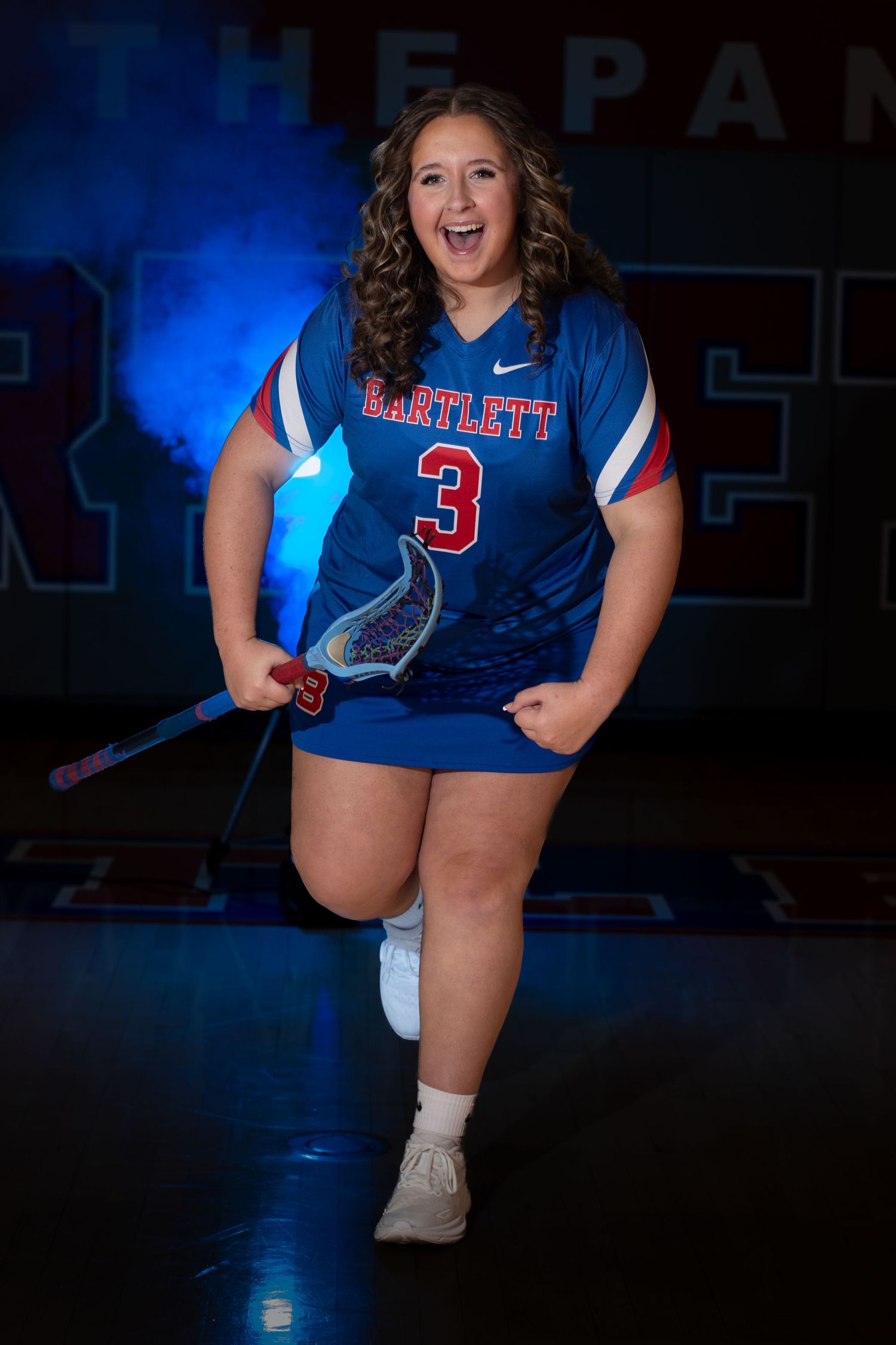 Bartlett lacrosse player number 3 posing energetically with stick in blue uniform.