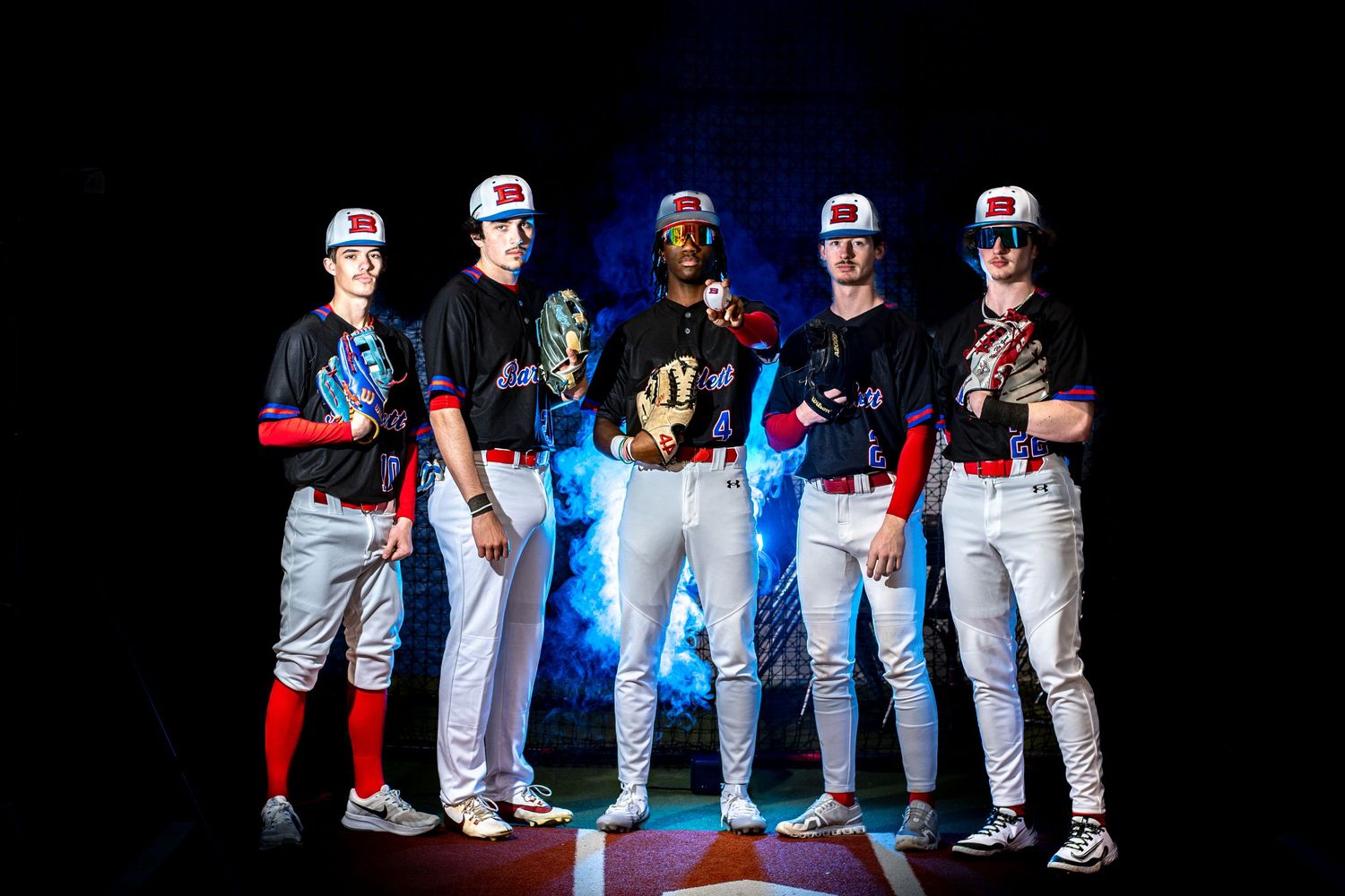 Five baseball players in red and black uniforms pose dramatically under blue lightning effects in a dark studio setting.