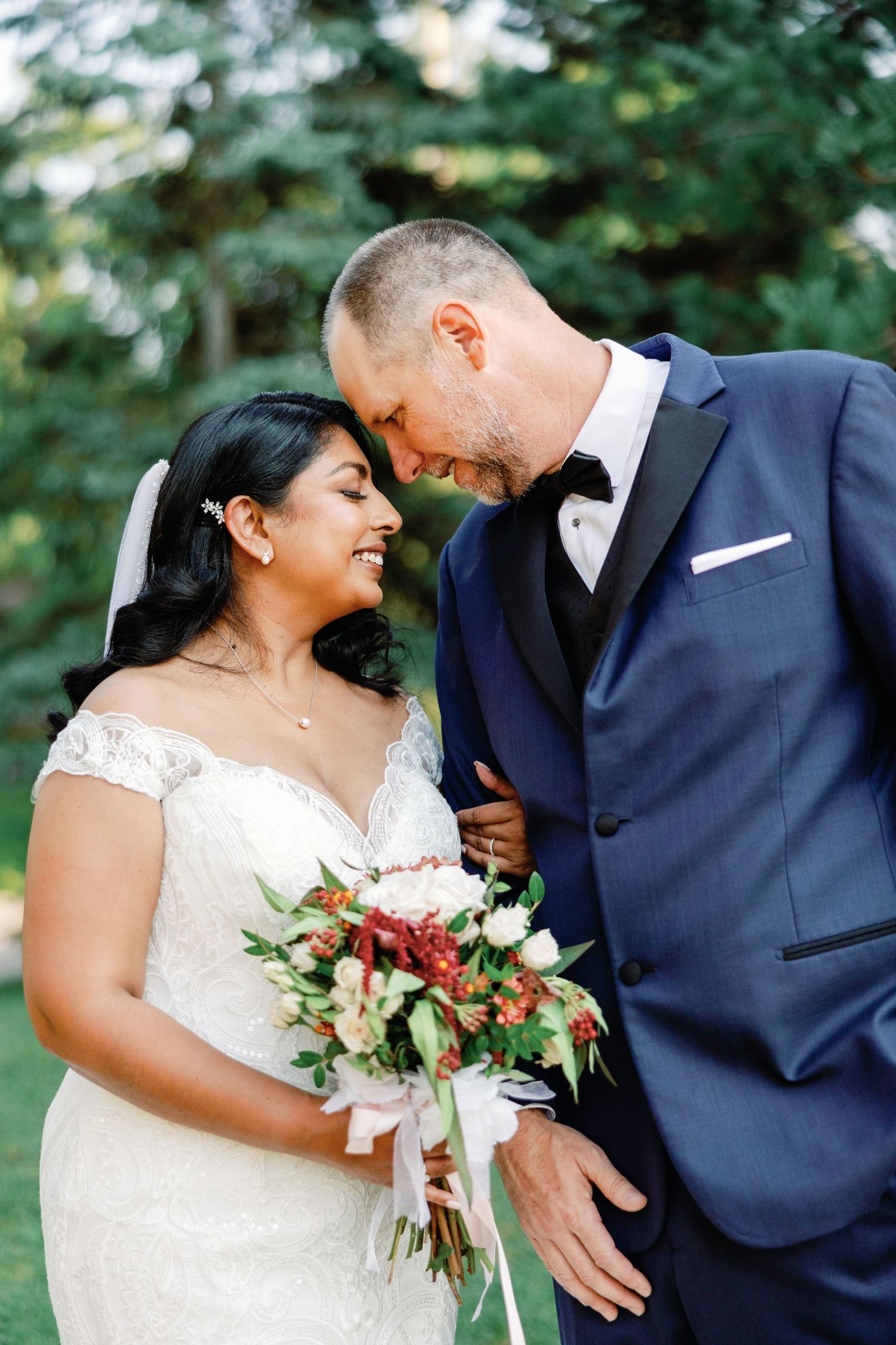 Romantic wedding portraits showing joyful laughter between newlyweds outdoors.