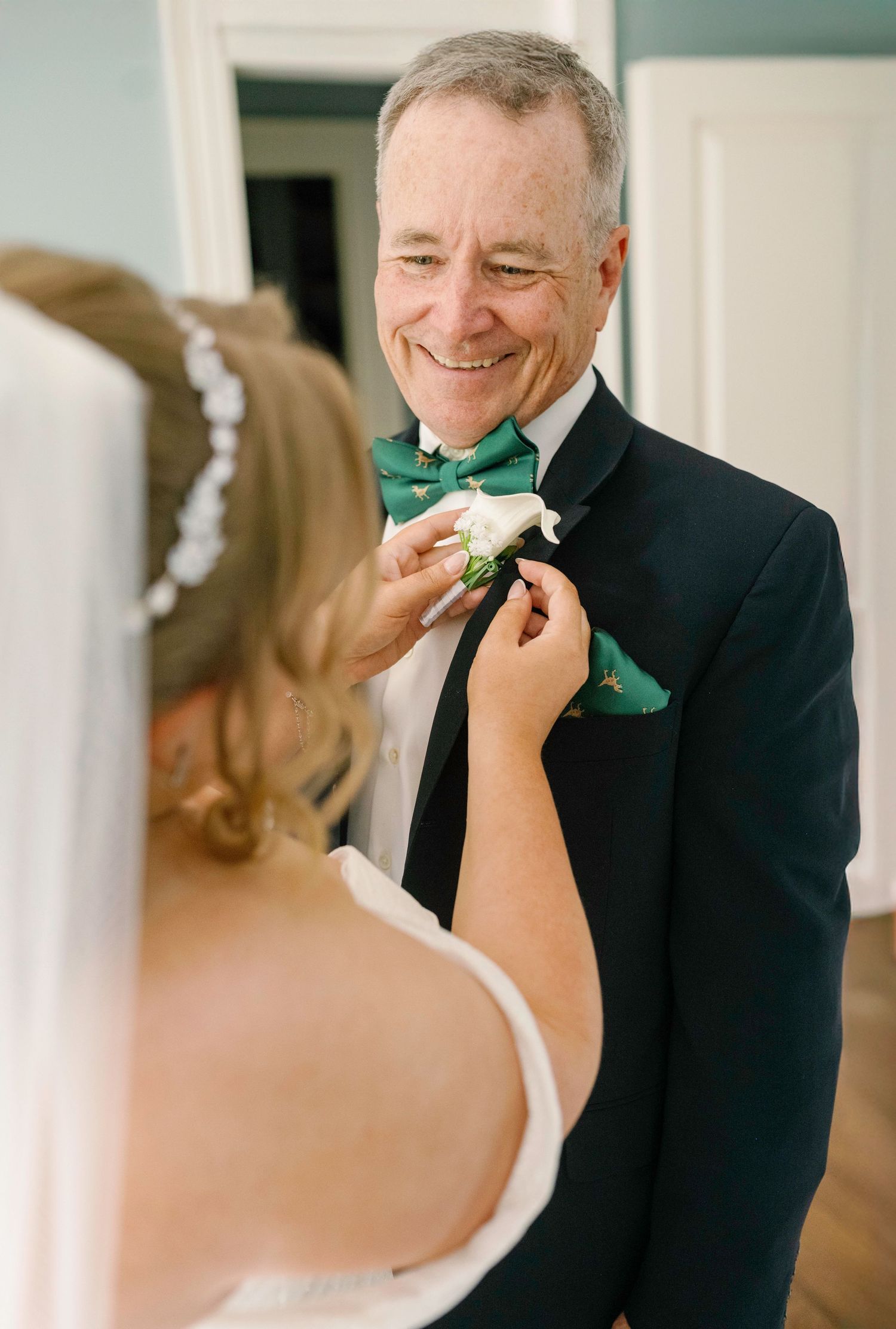 Sweet first look moment with formal attire and green bow tie.