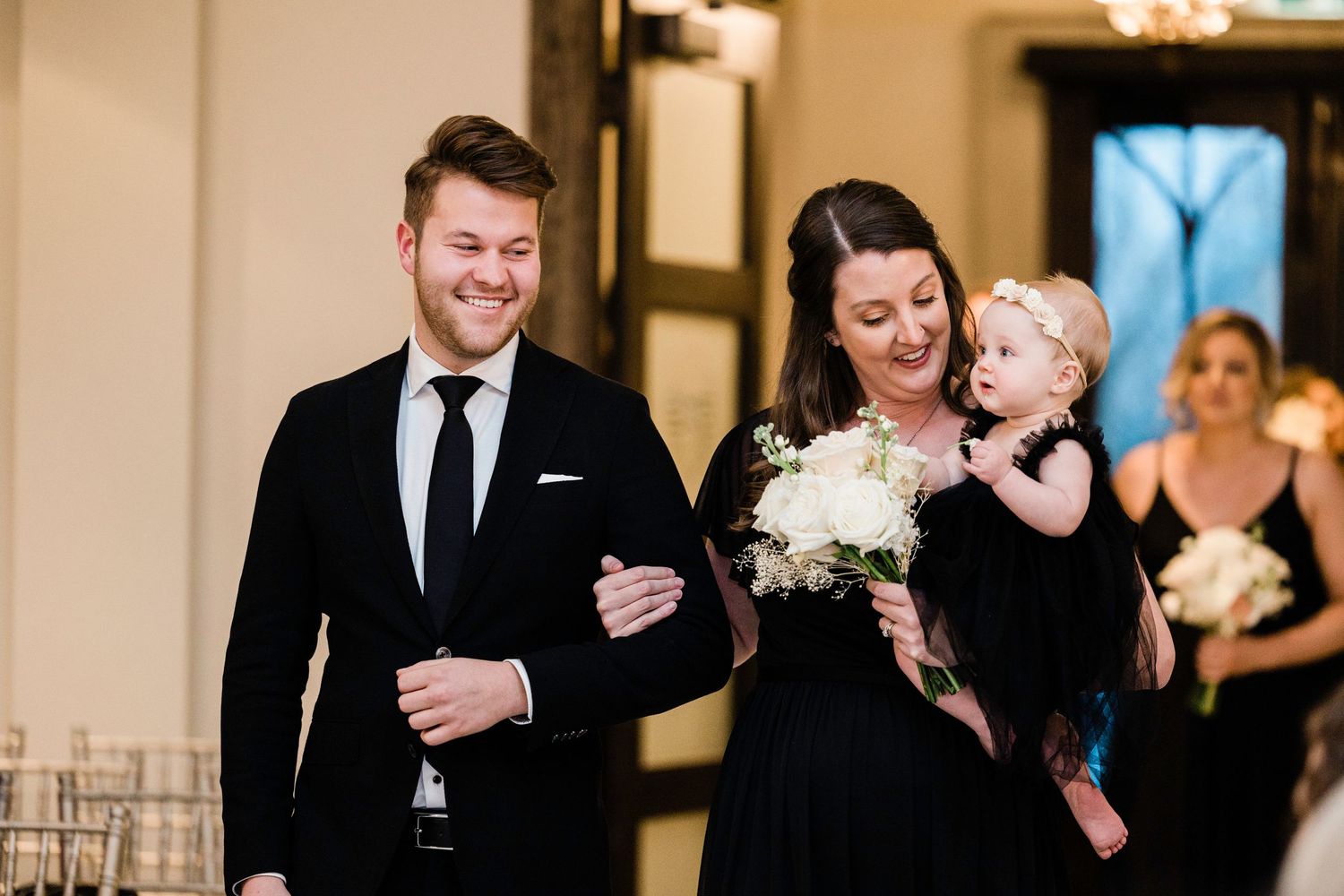 Wedding ceremony guests sharing joyful moments during an elegant indoor celebration.