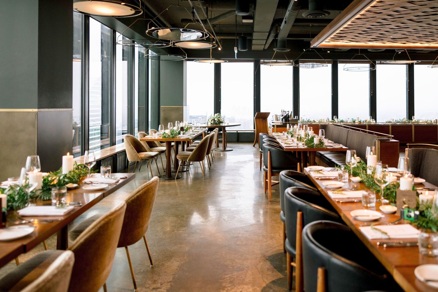 Modern restaurant interior with floor-to-ceiling windows and contemporary dining setup.