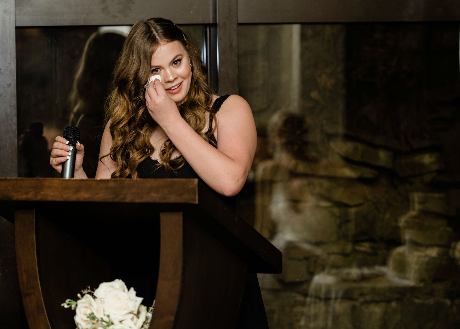 Wedding reception guests enjoy evening entertainment in rustic venue setting.