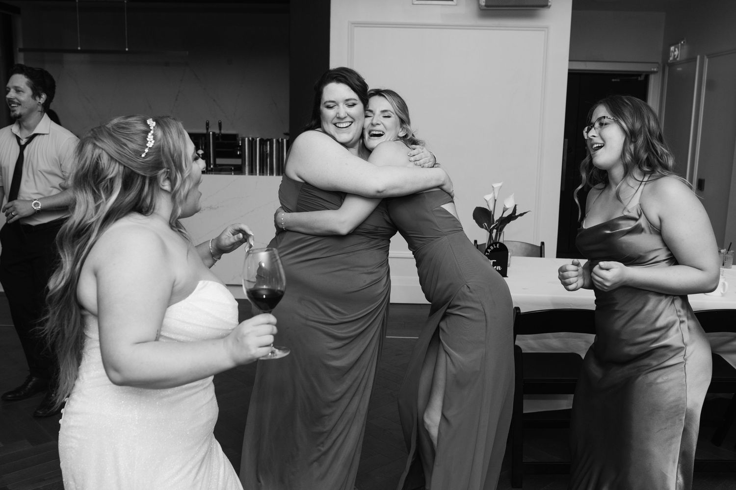 Black and white photo of wedding party dancing and celebrating together.