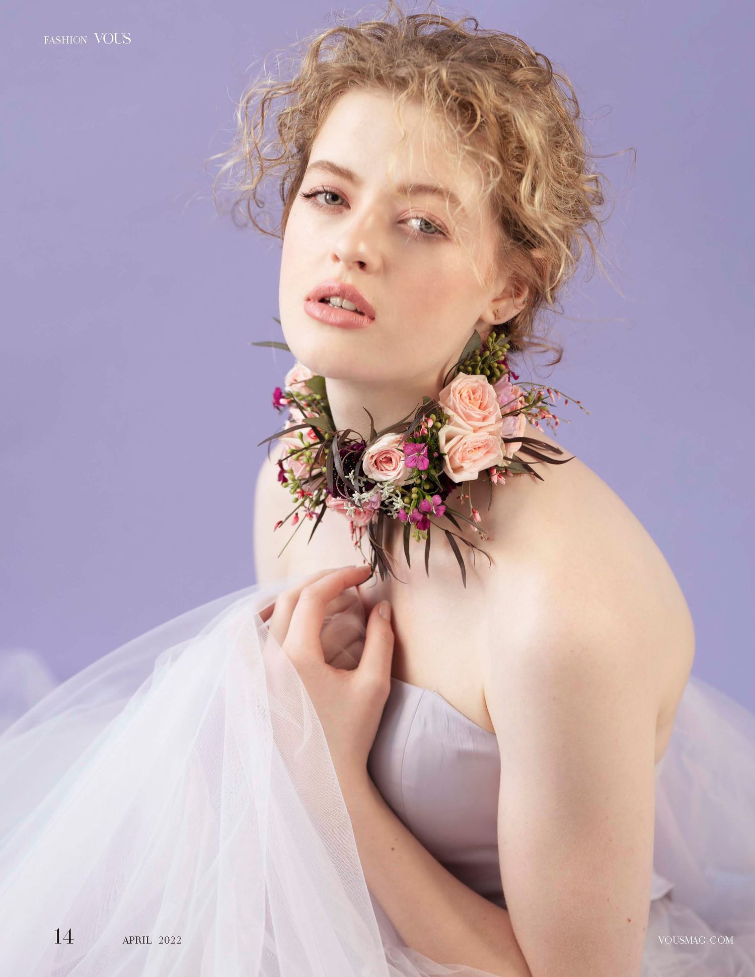 Romantic fashion portrait with floral neck piece and tulle dress against purple background.