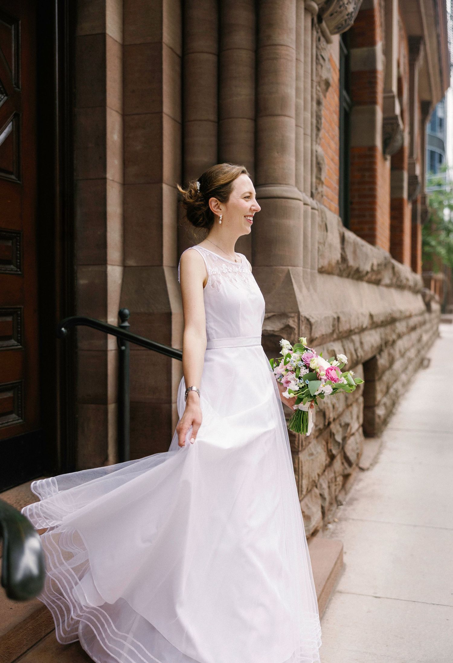 A flowing white wedding dress twirls along a historic stone colonnade.