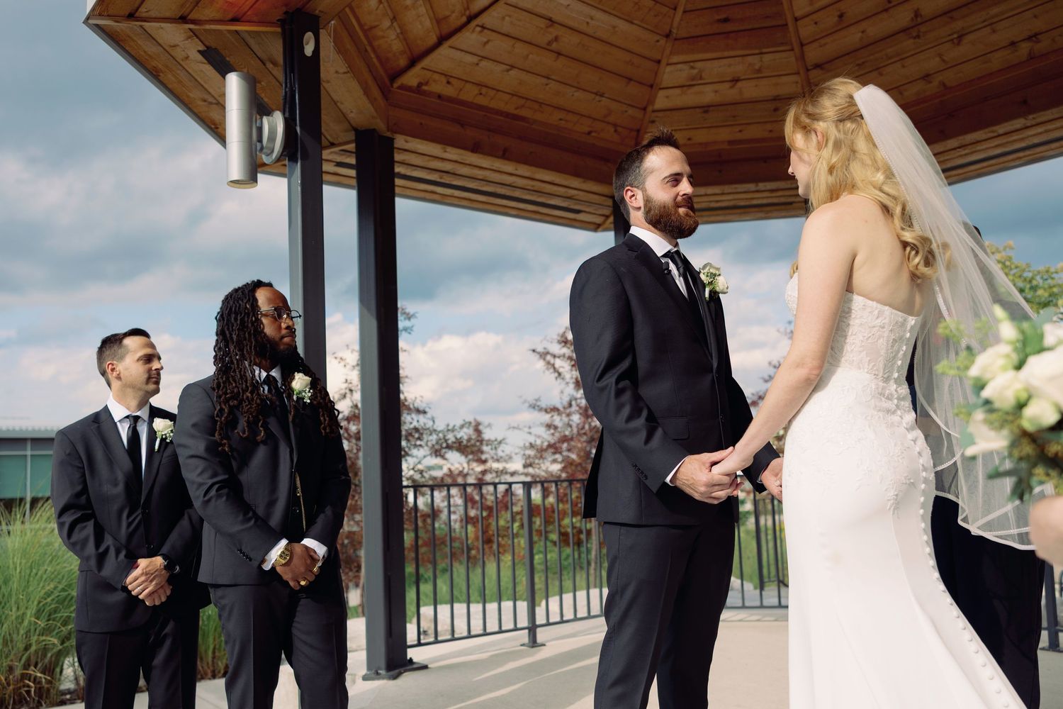 A couple in wedding attire share intimate moments during their outdoor ceremony and reception.
