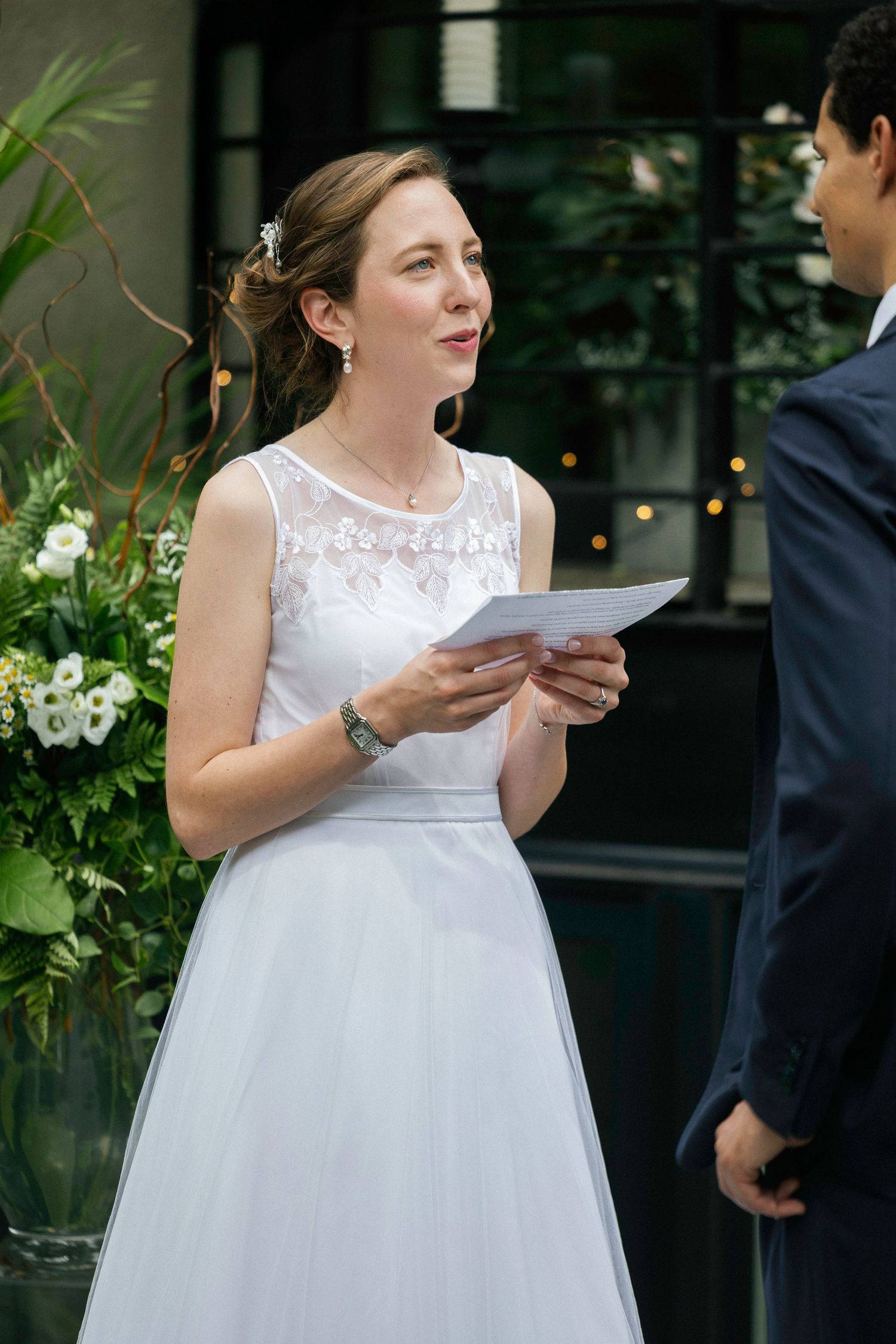 Wedding couple sharing a special moment while reading letters outdoors.