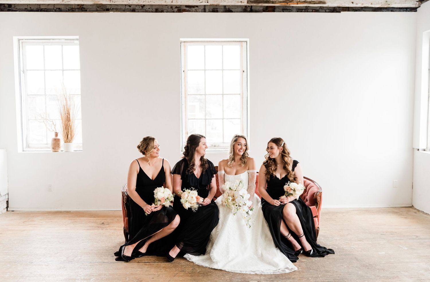 Panoramic wedding party portrait in bright minimalist white room.