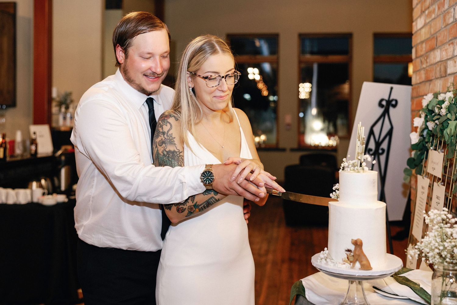 A couple cuts into their wedding cake together during a traditional cake-cutting ceremony.