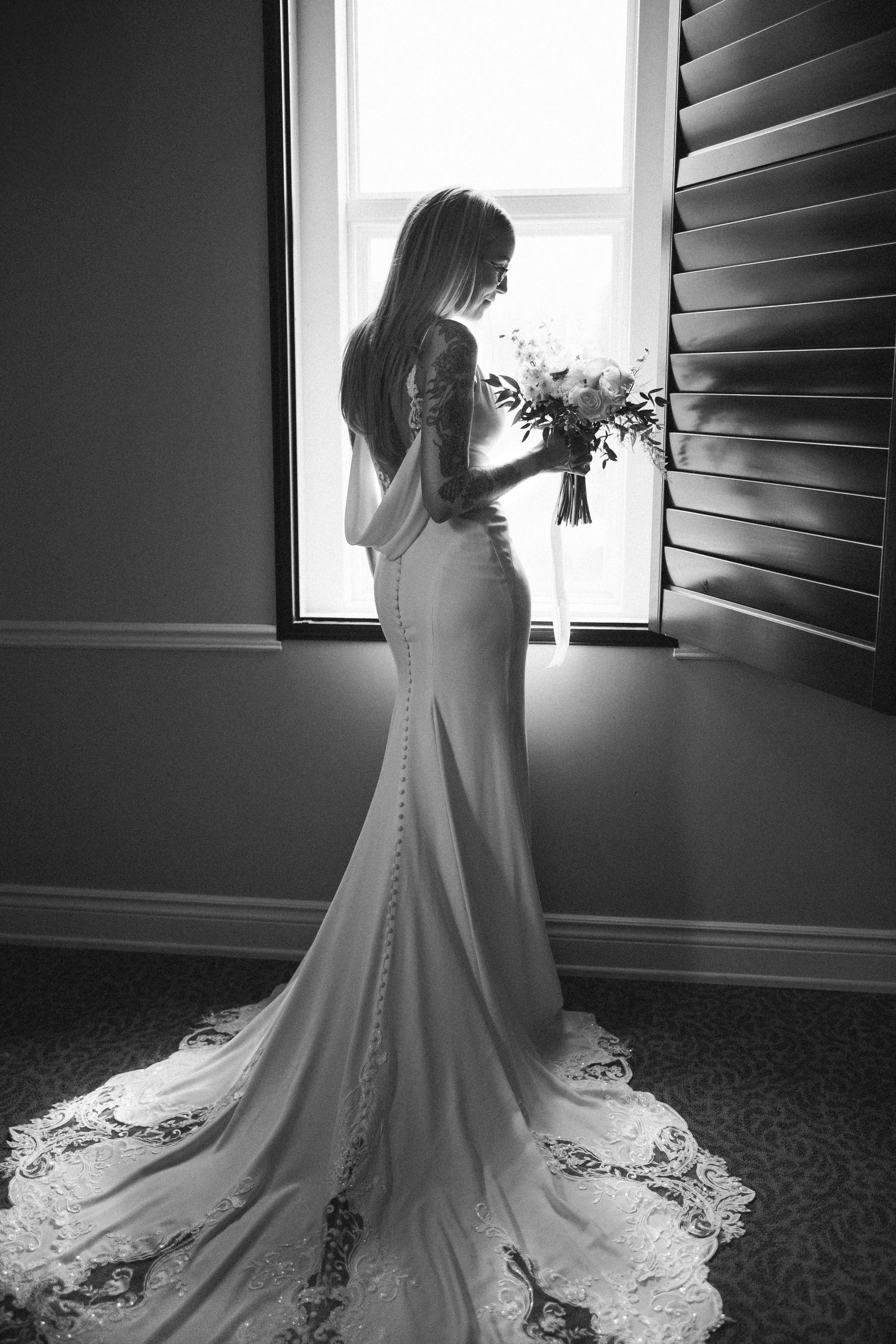 A series of black and white photos showing the back details of a wedding dress with buttons and lace train.