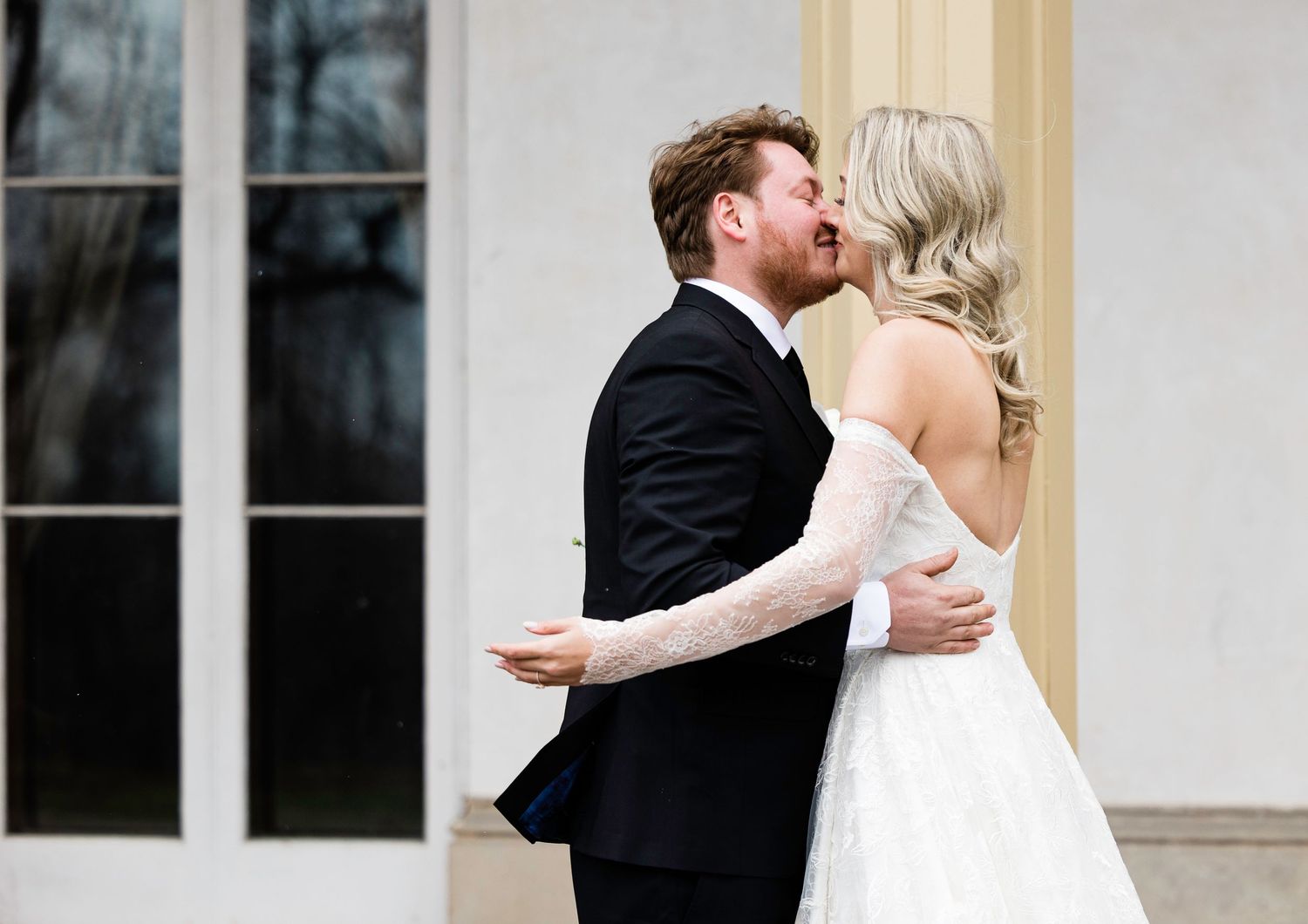 Intimate wedding couple moment captured in front of classic architecture.
